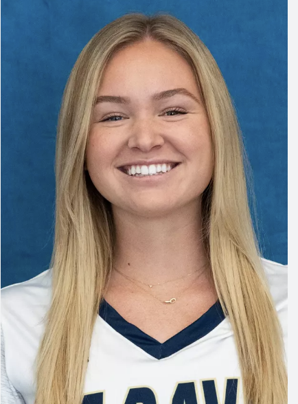 Person smiling in Dayton sports jersey with blonde hair