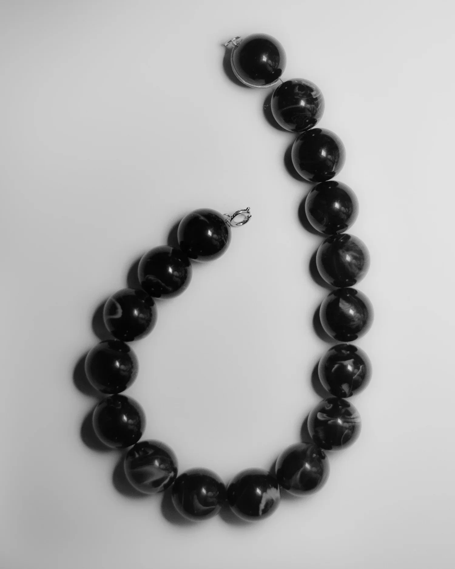 Black pearl necklace and earrings on a white surface
