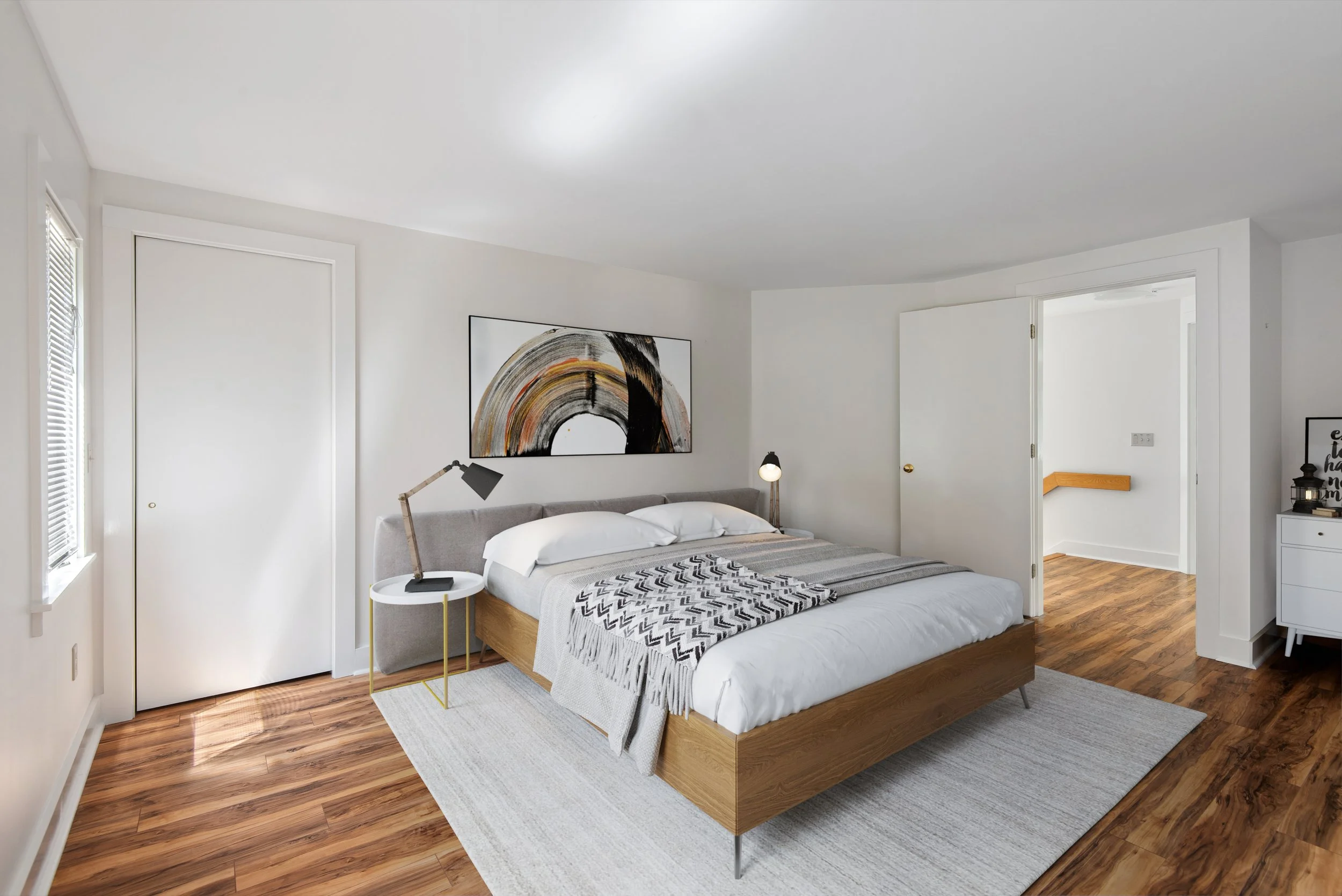 A modern bedroom with a wooden bed frame, gray headboard, white bedding, black and gray throw blanket, two wall-mounted lamps, a white rug, and a large abstract painting above the bed.