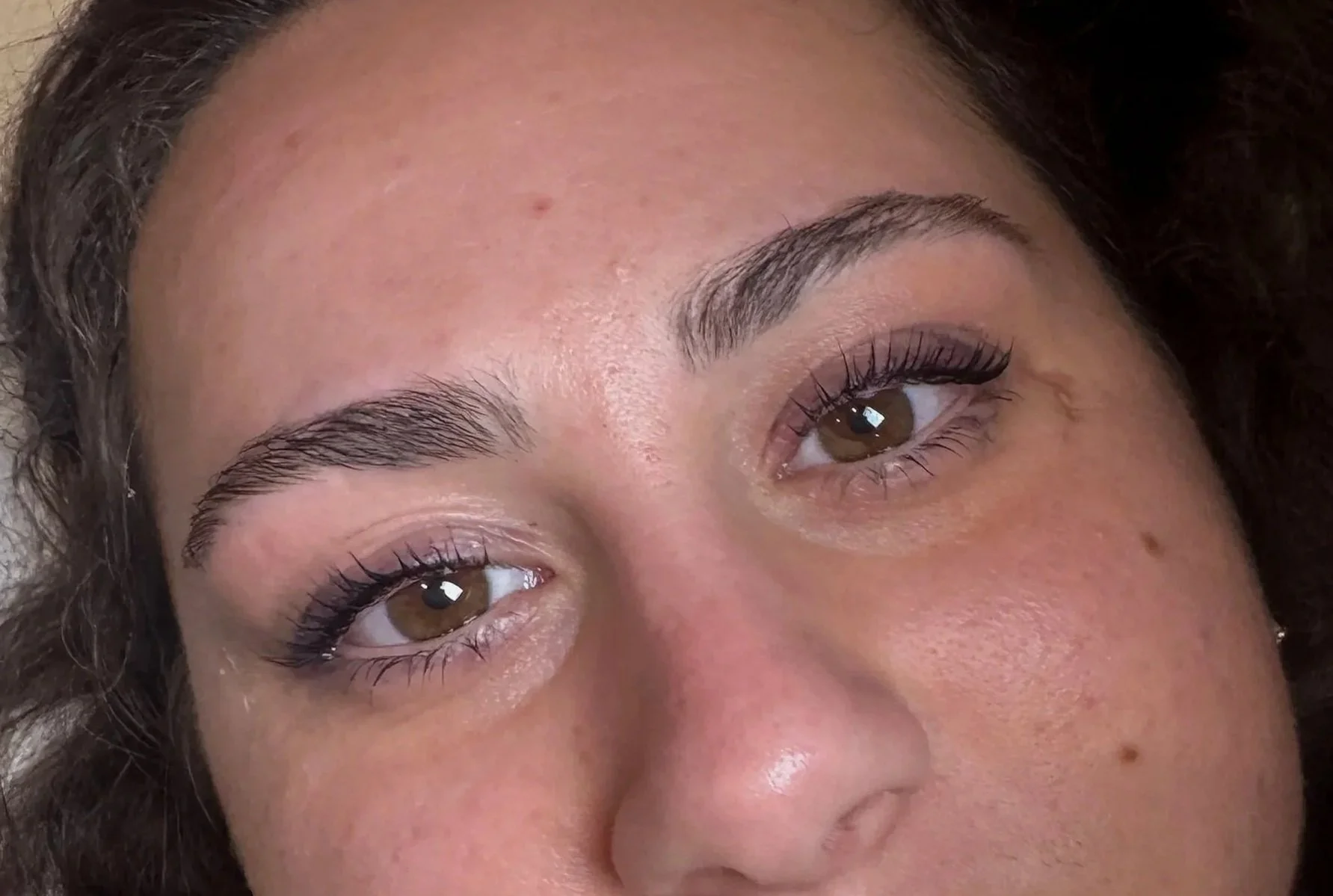 Close-up of a closed eye with well-groomed eyebrows and long eyelashes.