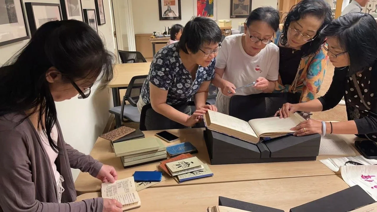 group looking at guestbooks and diaries