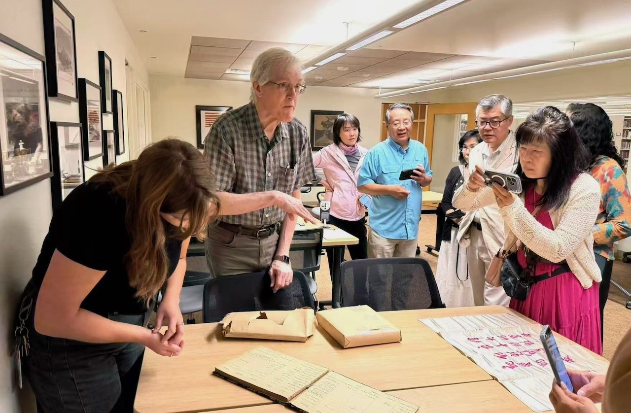 Chris Hoogendyk unwrapping and presenting guestbooks and diaries to the Whitman archives