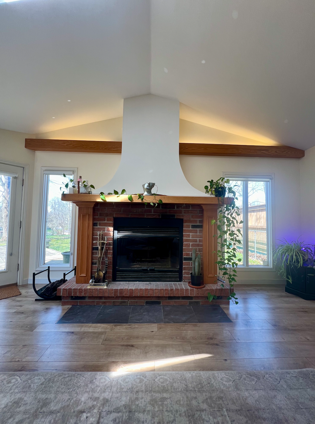 Another view of the completed living area renovation in West London by Burcon Construction, highlighting new laminate floors and fireplace.