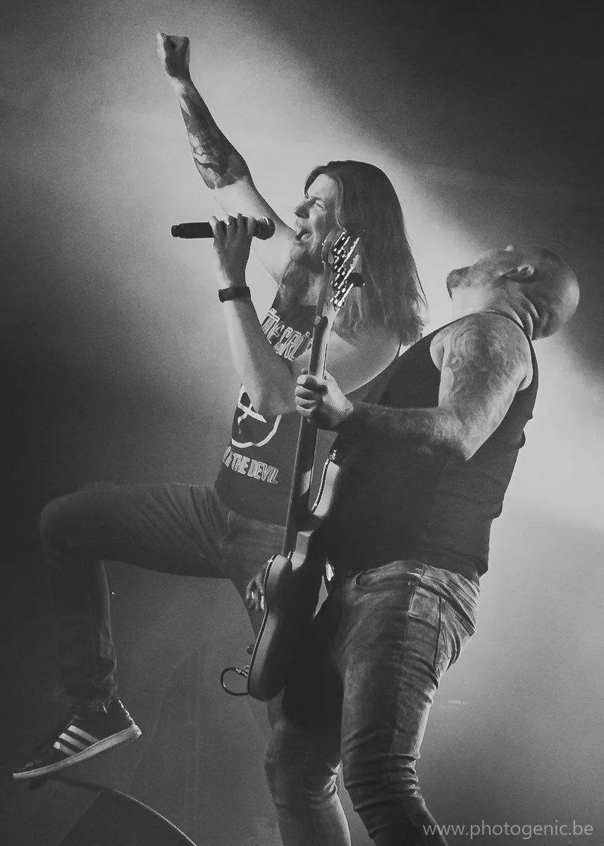 Twee muzikanten die samen optreden op een podium, een zangeres met microfoon en een gitarist, zwart-wijn foto.