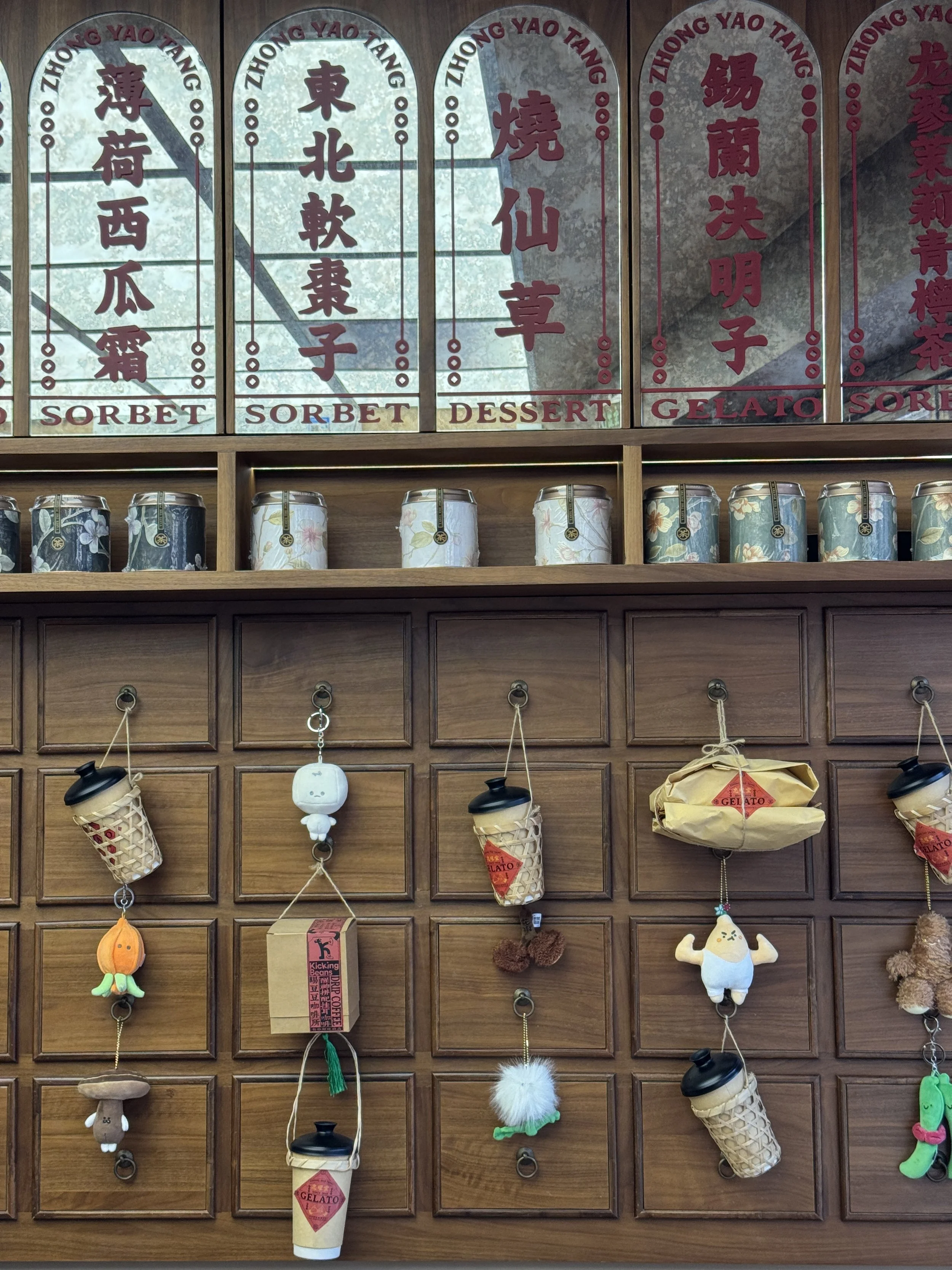 Traditional Chinese medicine herb plushies hanging from wooden drawers