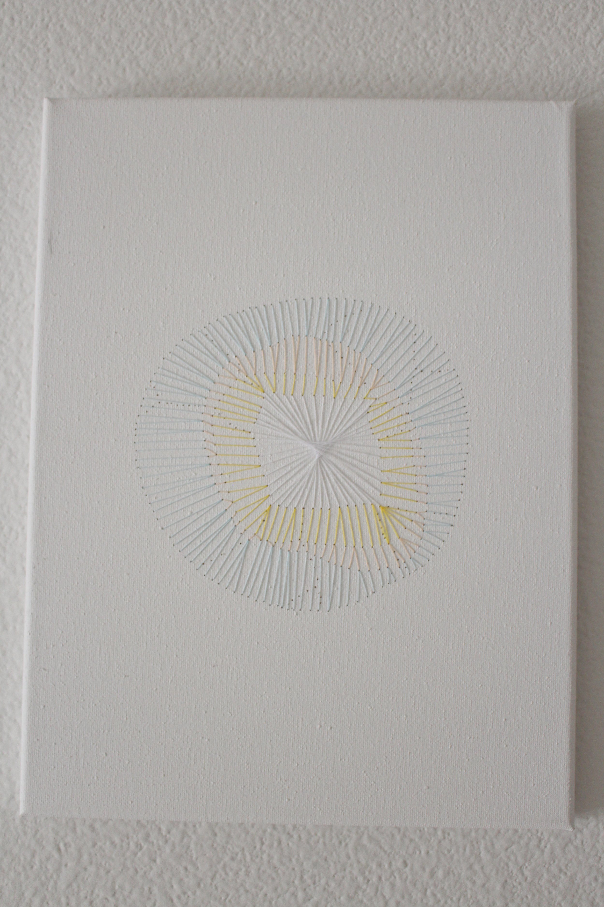  White, yellow, and blue orb sewn into a canvas 