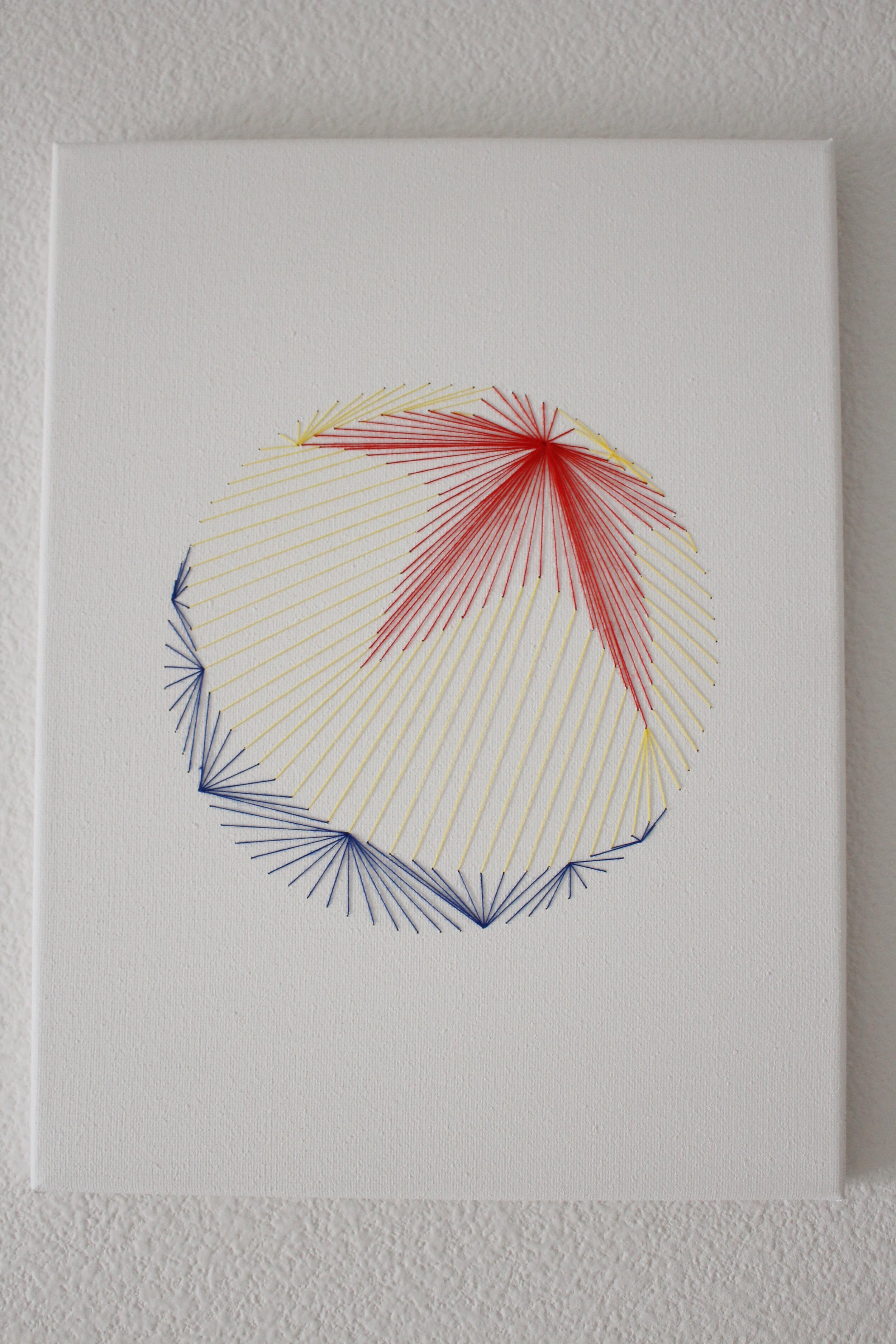  Red, yellow, and blue thread sewn into a canvas in the shape of a Pixar ball 
