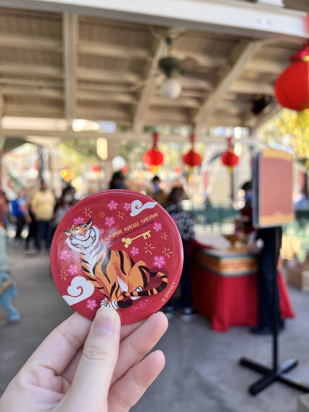  Red metal button with a tiger cartoon drawn on it and the words LUNAR NEW YEAR printed with a Mickey head shaped key 
