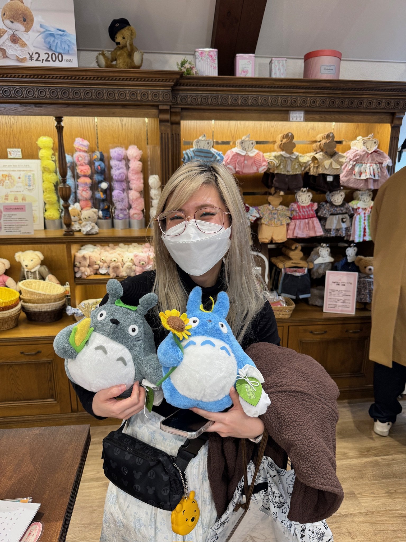  holding two Totoro plushies 