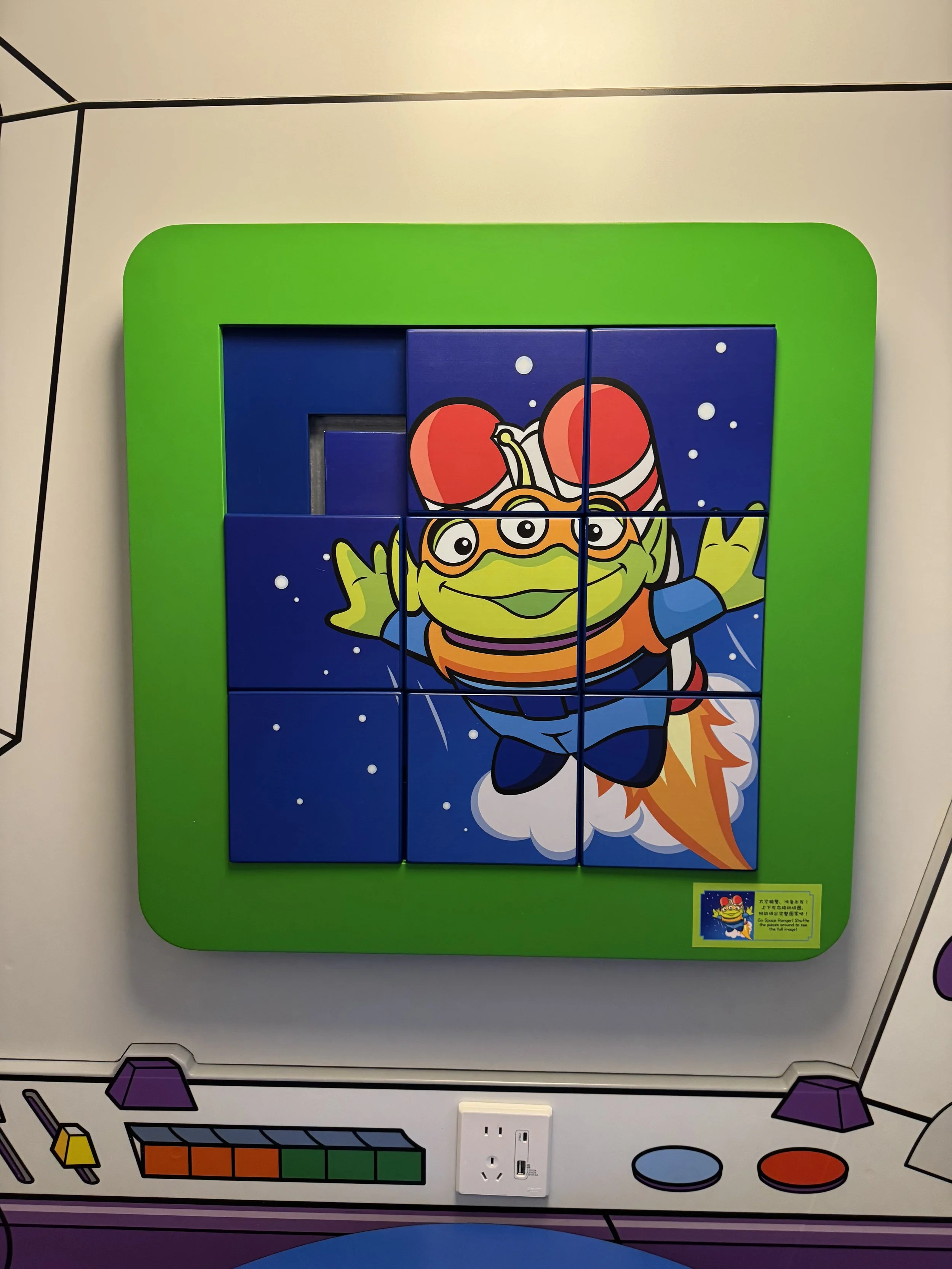 Alien-themed sliding puzzle wall art in Toy Story Hotel