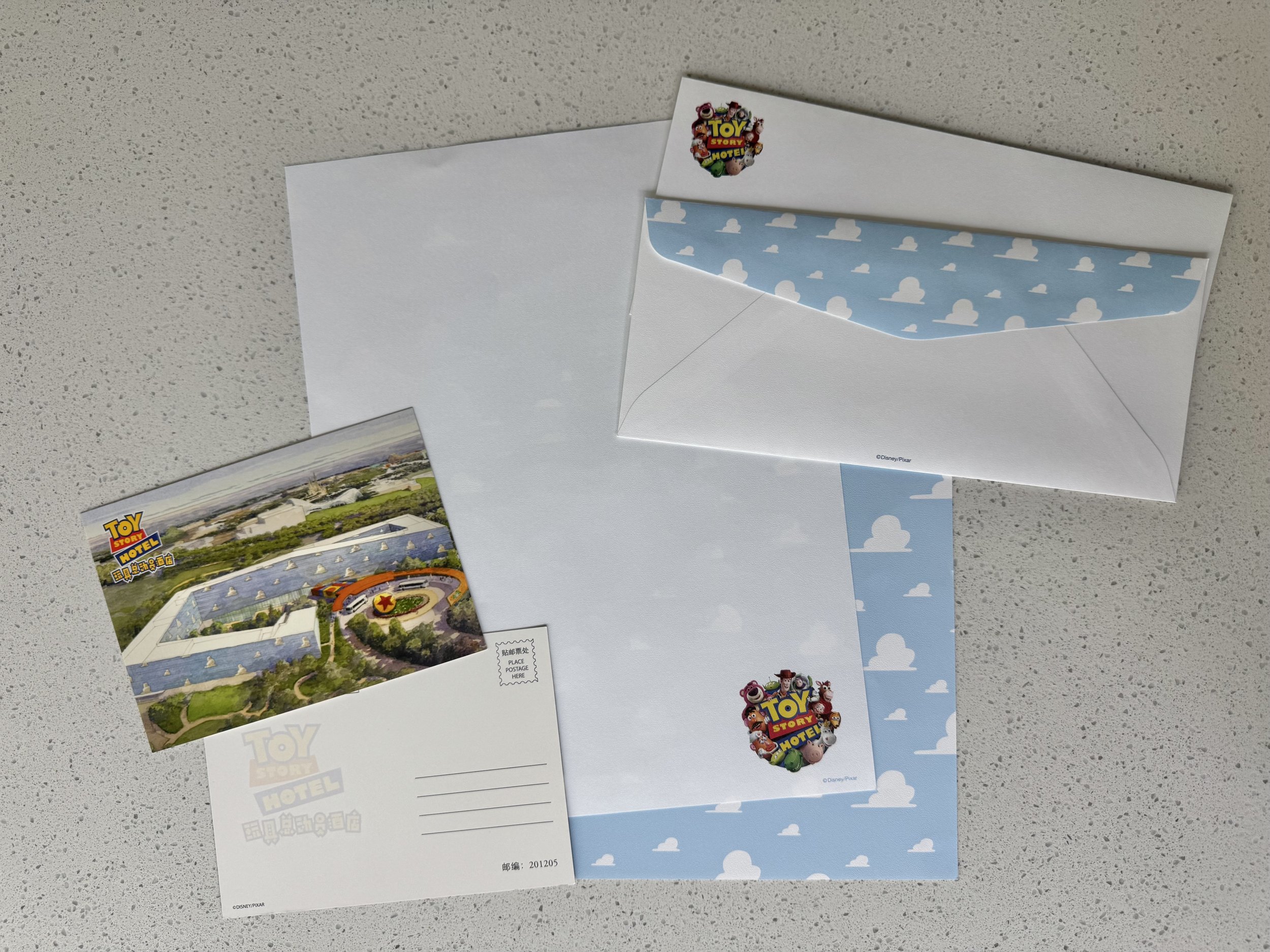 Top view of two postcards, two letter papers, and two standard letter envelopes in Toy Story Hotel theme