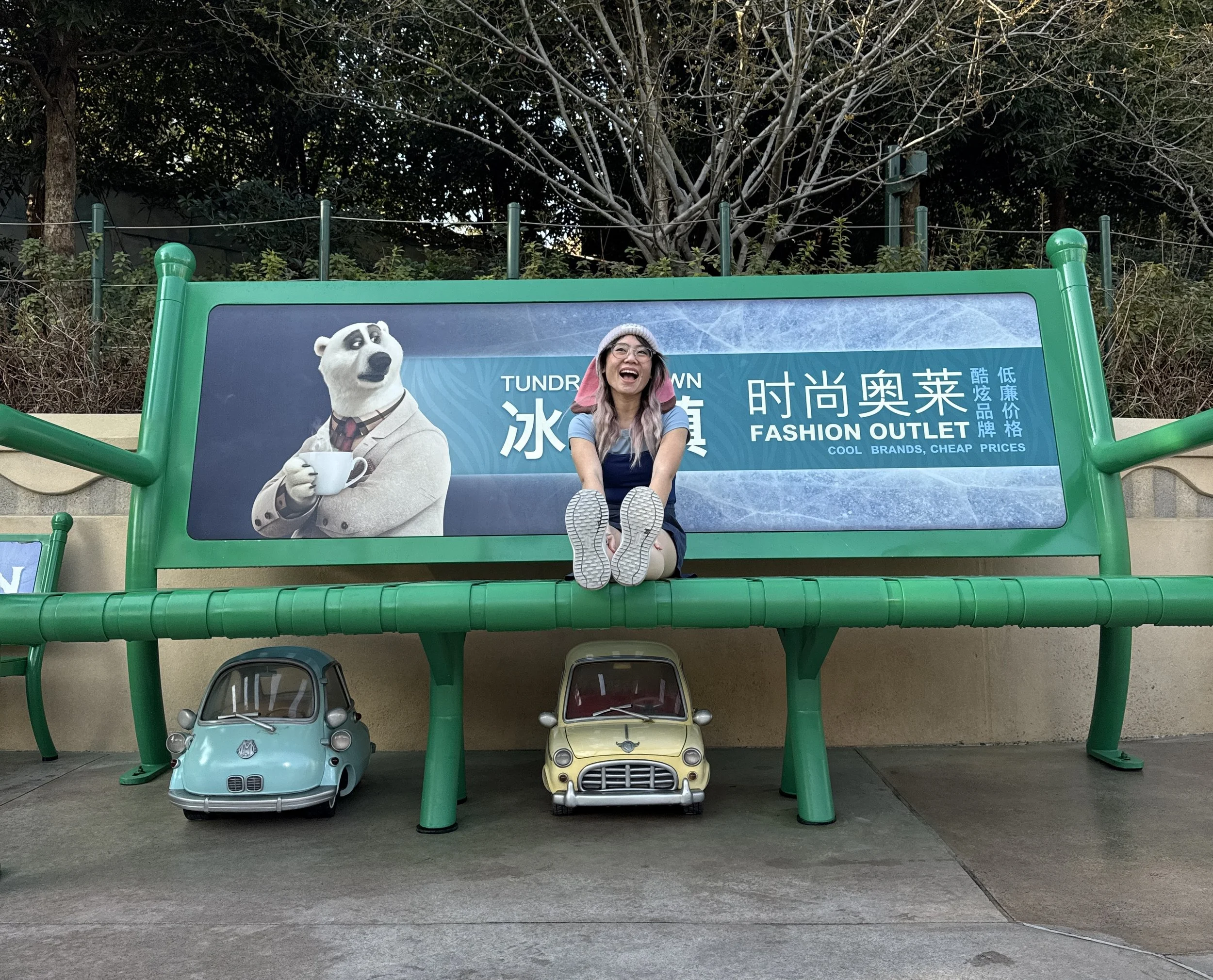 Sitting on a giant bench in Zootopia with a Polar Bear Tundra Town ad