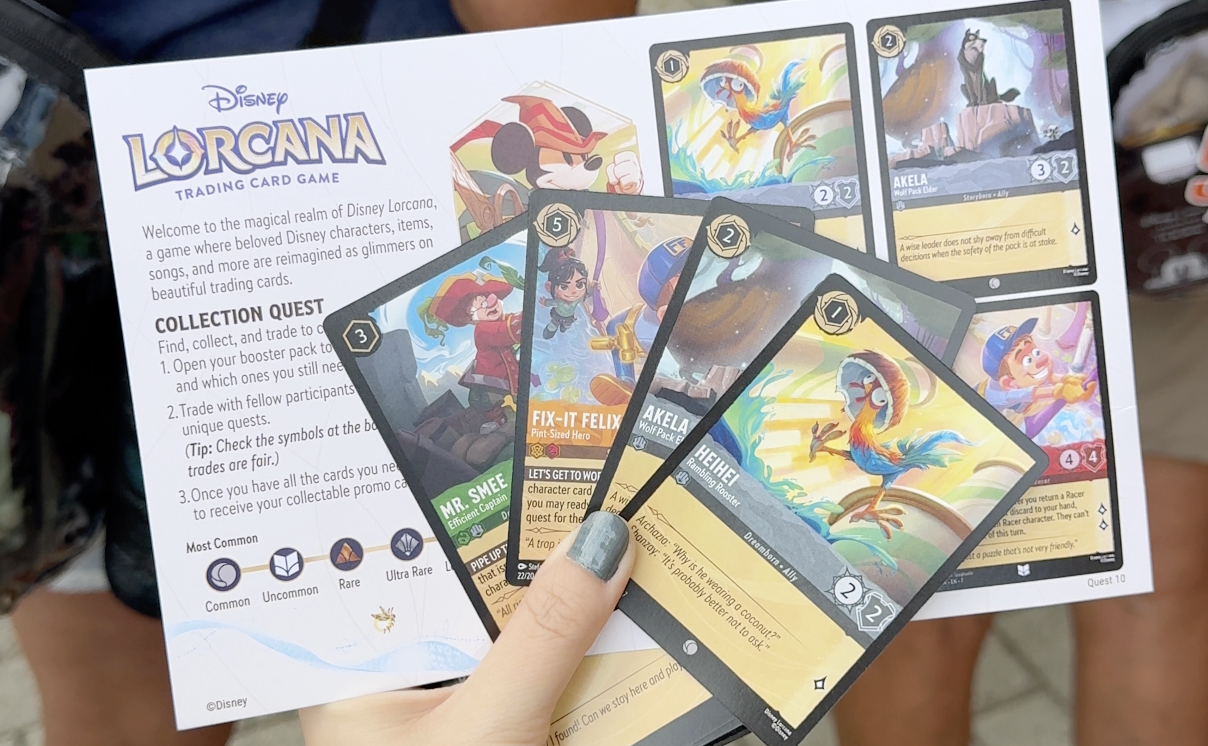 4 Lorcana cards on top of a collection quest card