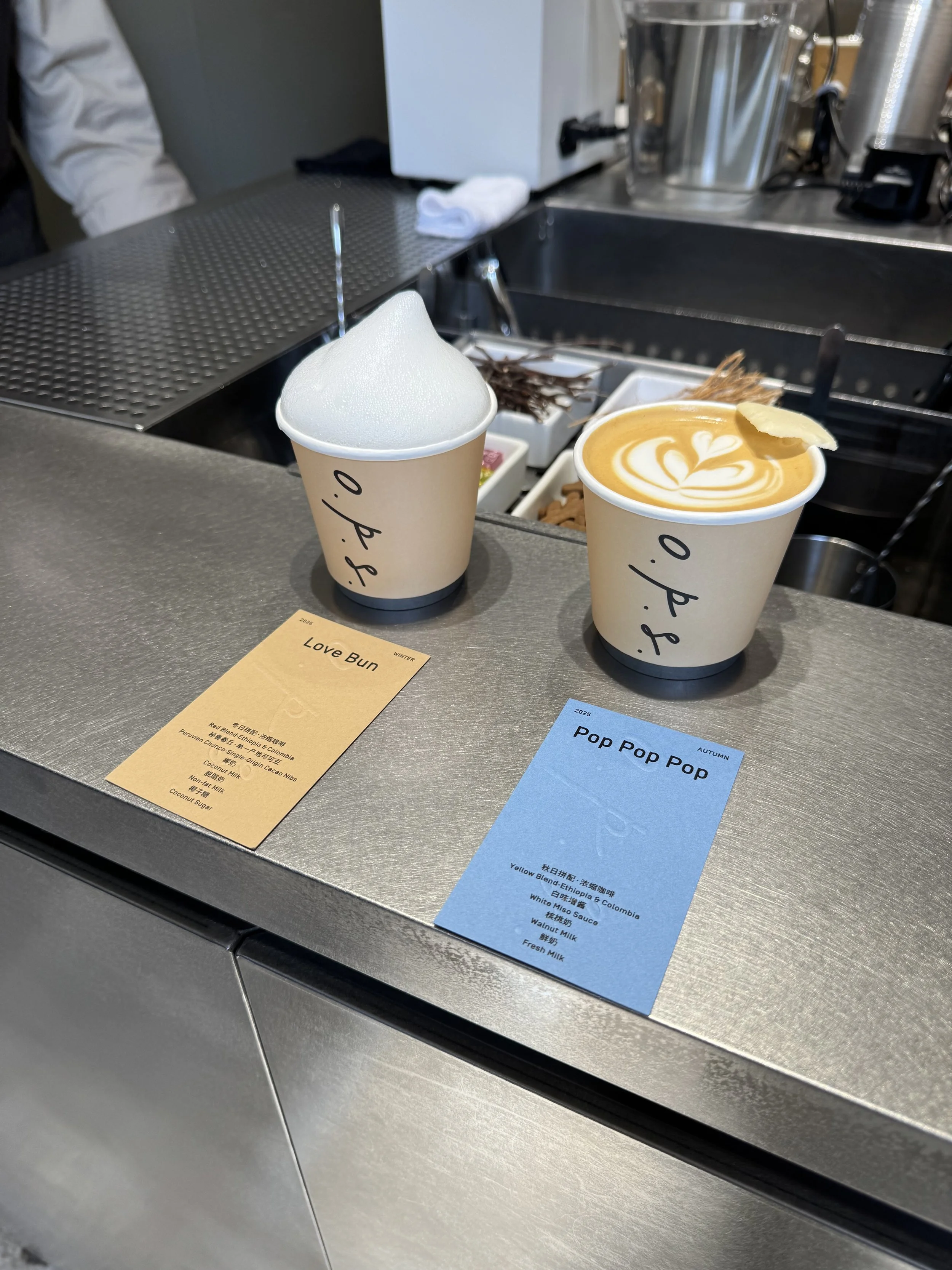 Two cups of coffees on a meta table with detail cards in front