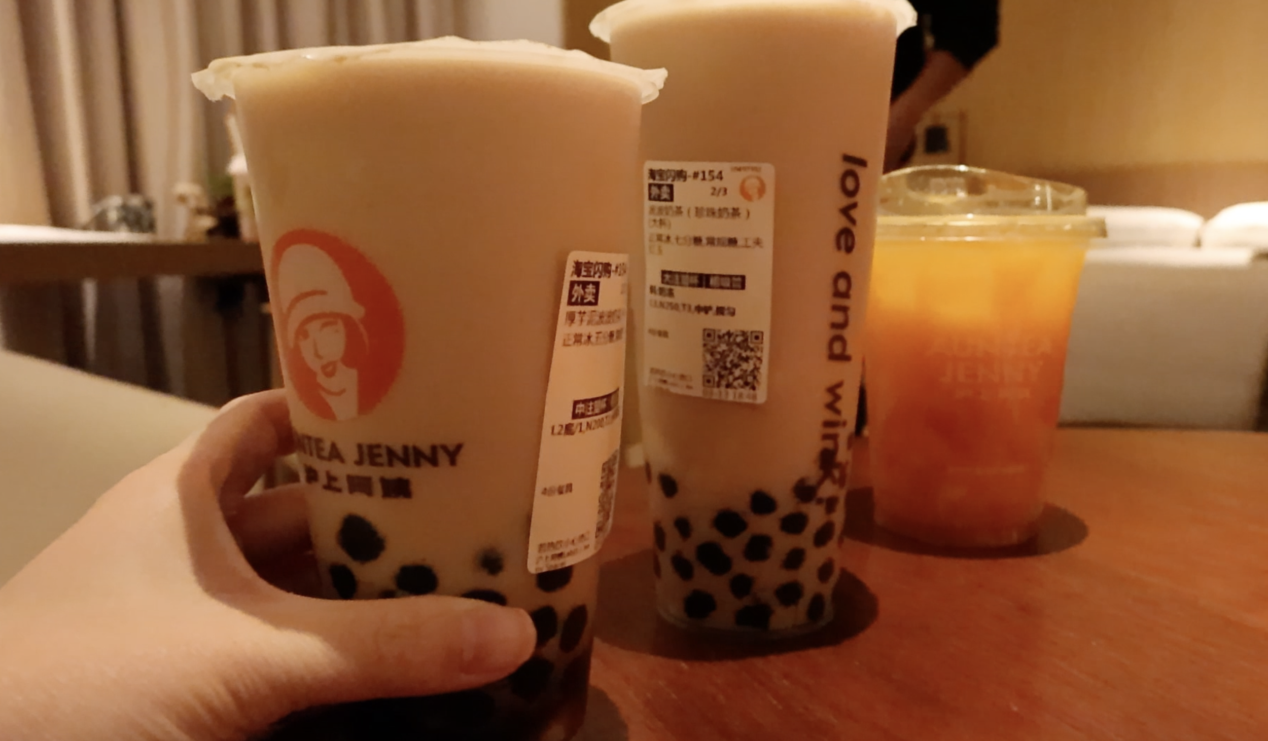 Three cups of boba on a brown table
