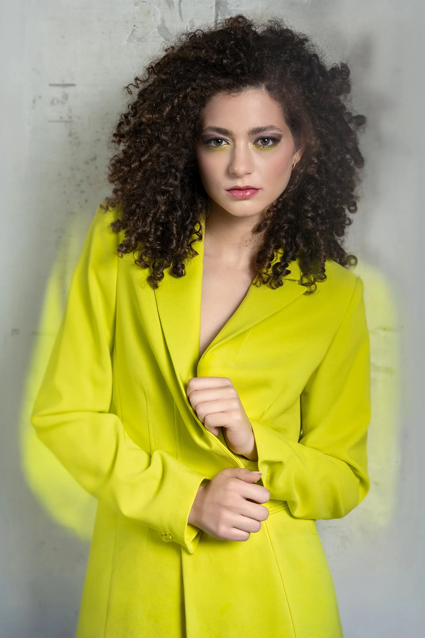 Young woman wearing neon green yellow DKNY blazer against concrete wall photographed in New York Los Angeles and Seattle 