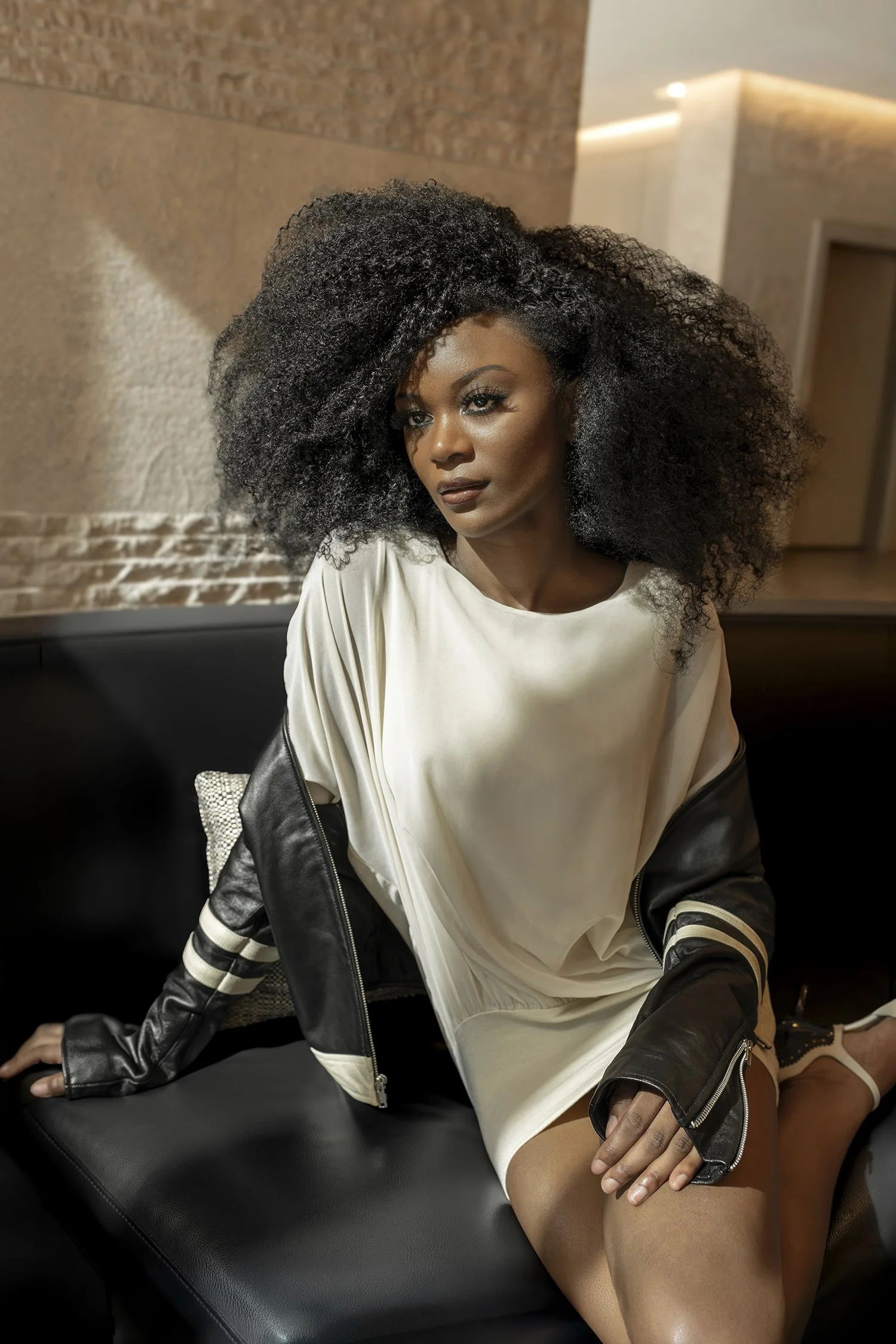 African American woman with afro hair sitting in hotel lobby window in natural light photographed in Seattle New York and Los Angeles