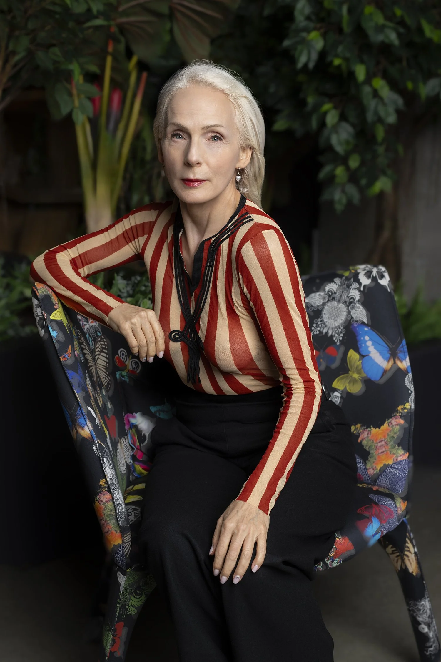 Mature female woman model wearing Jean Paul Gaultier blouse siting on Roche Bobois Butterfly chair photographed in New York Los Angeles and Seattle