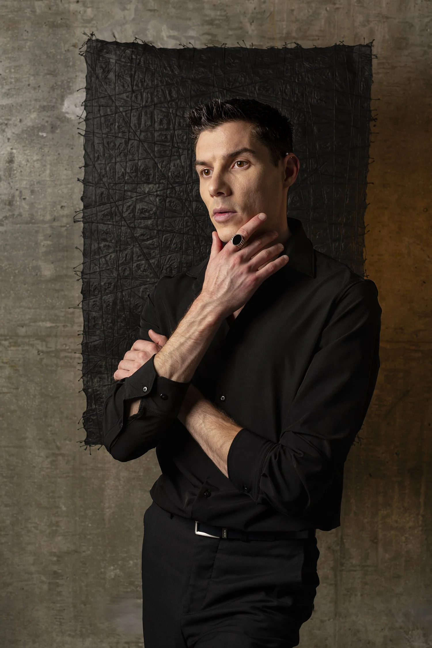 Man in black dress shirt and pants with black onyx ring photographed in Seattle in photography studio