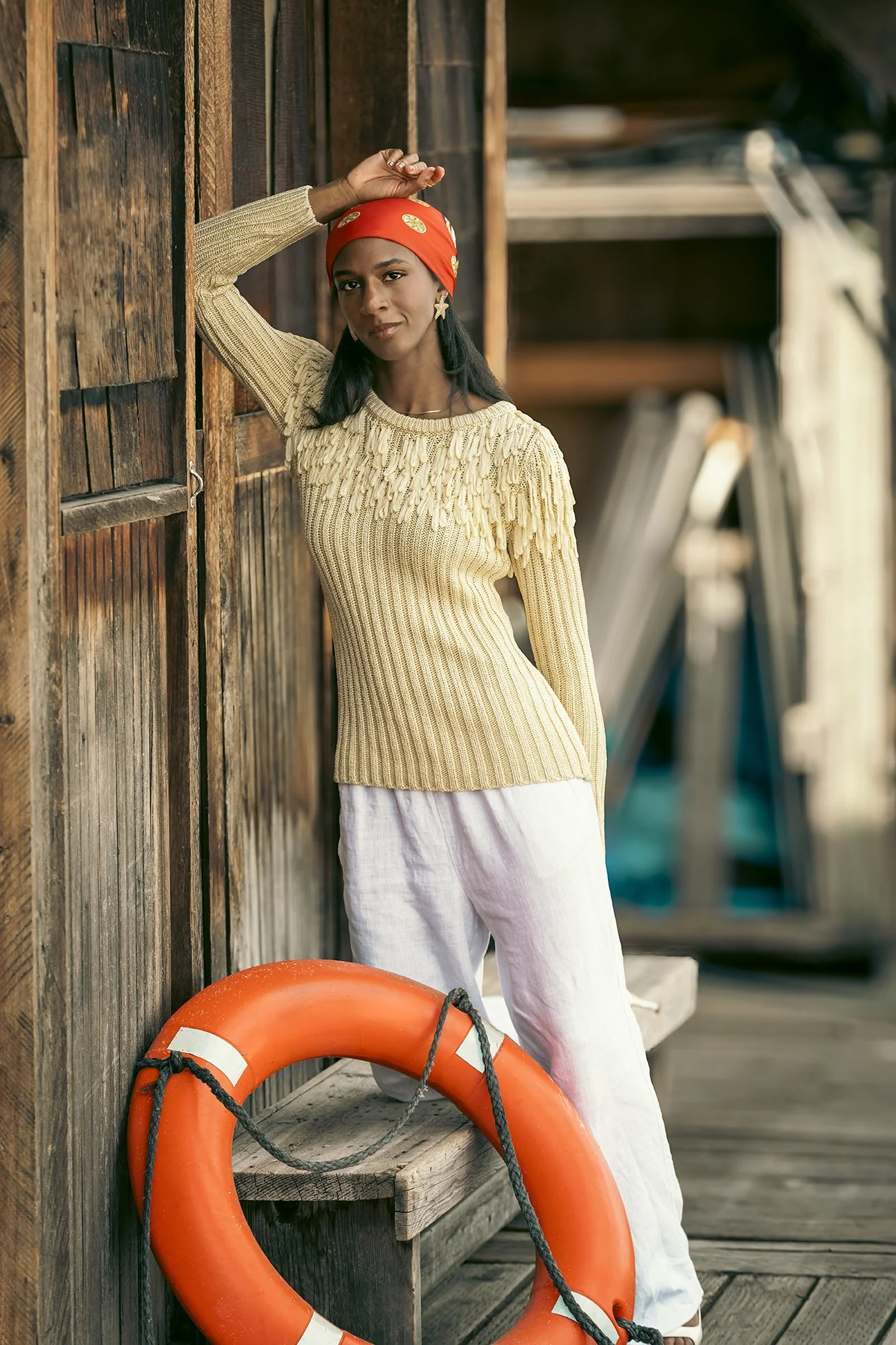Woman wearing silk head scarf and nautical themed outfit with orange life preserver on yacht in Seattle 