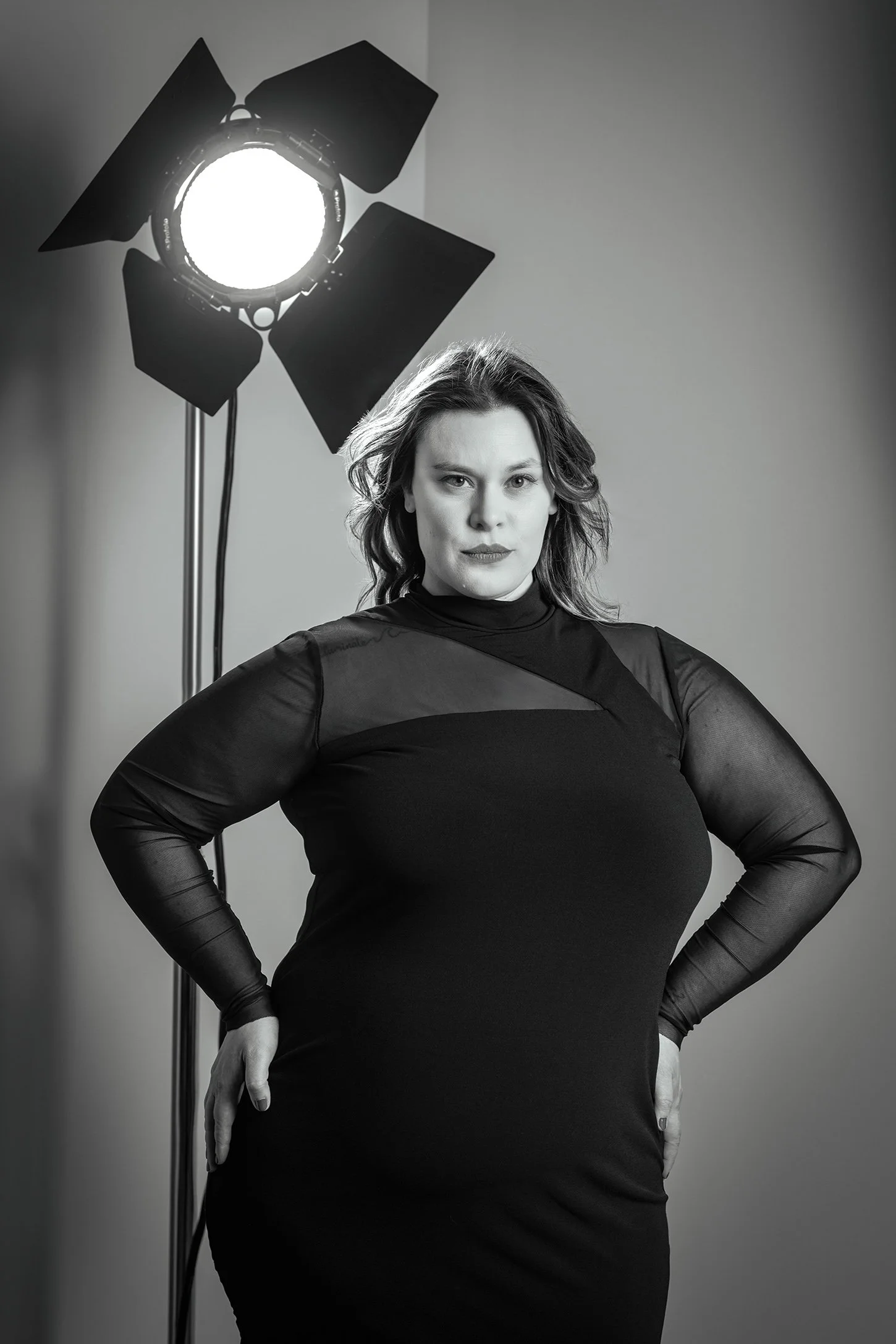 Plus size woman in black dress photographed in studio in Seattle Los Angles New York.  Profoto light with barn doors and grid 