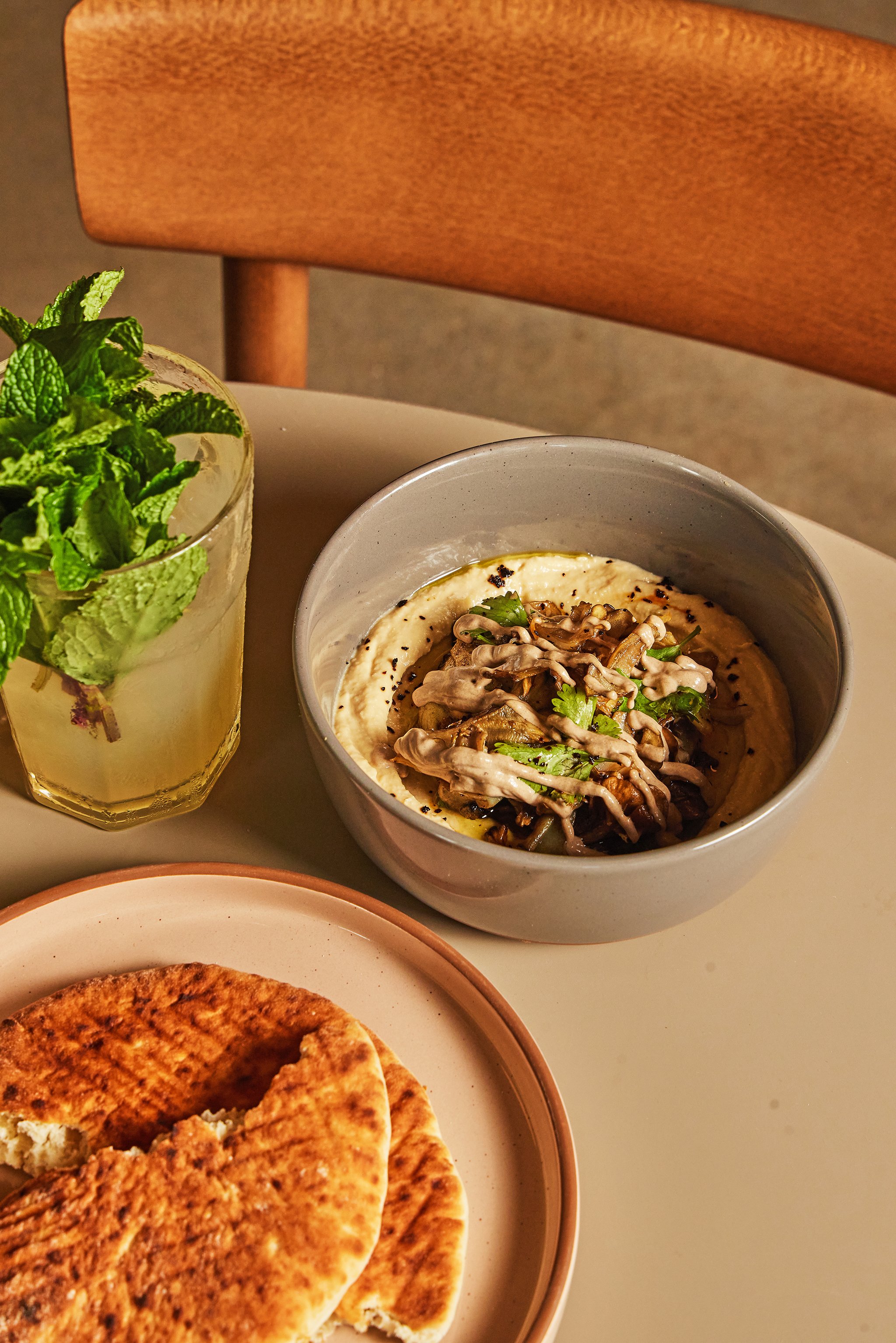 An Amba hummus bowl and a Cool Mint Arnold Palmer in the space with some pitas
