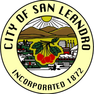 Seal of the City of San Leandro featuring a landscape with mountains, a rising sun, and a cherry with green leaves and red fruit, surrounded by the text 'City of San Leandro' and 'Incorporated 1872'.
