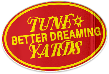 Oval logo with red background and yellow border, featuring the words 'Tune Better Dreaming Yards' in yellow text.