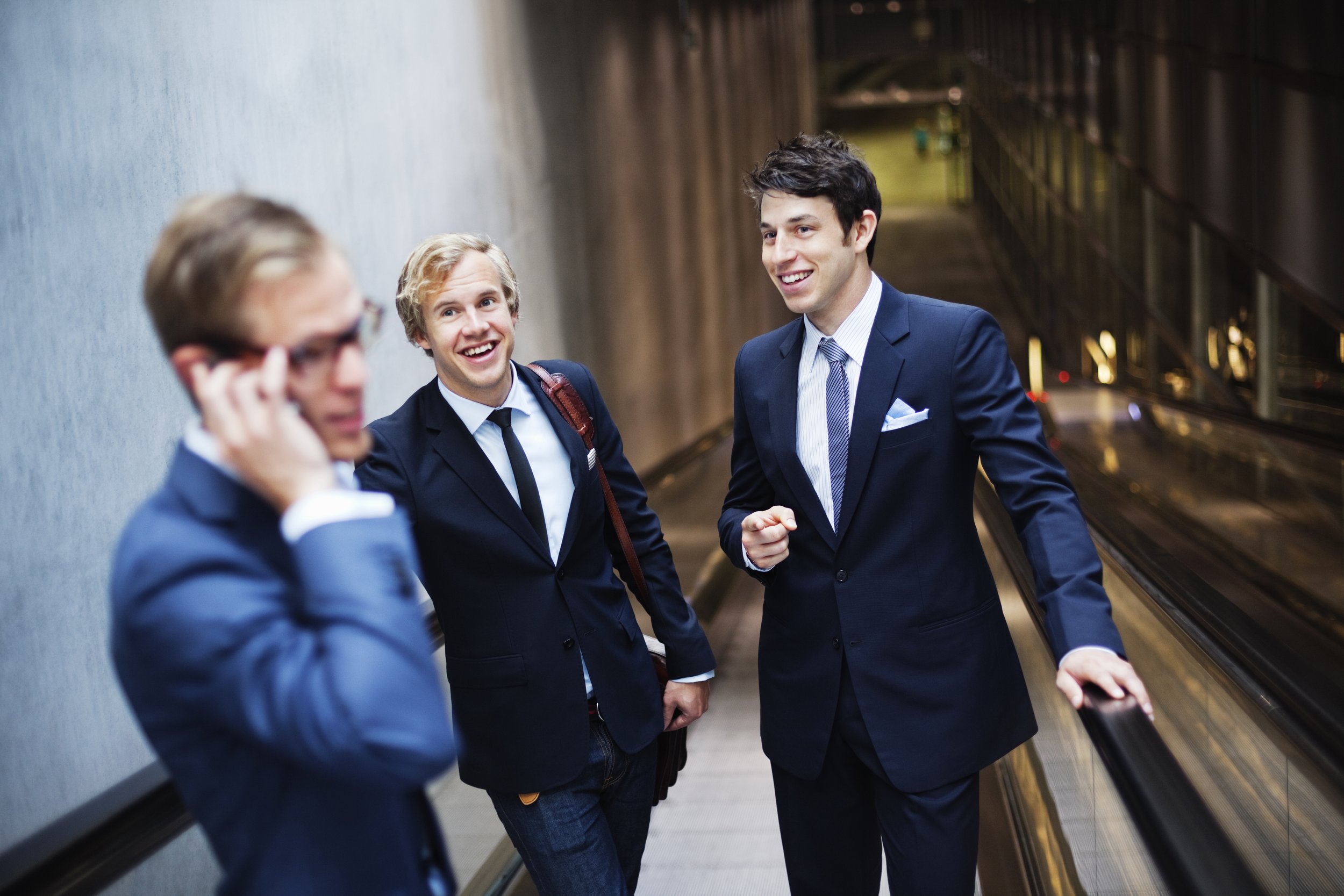 happy-business-colleagues-on-escalator-at-railroad-2023-11-27-05-28-49-utc.jpg