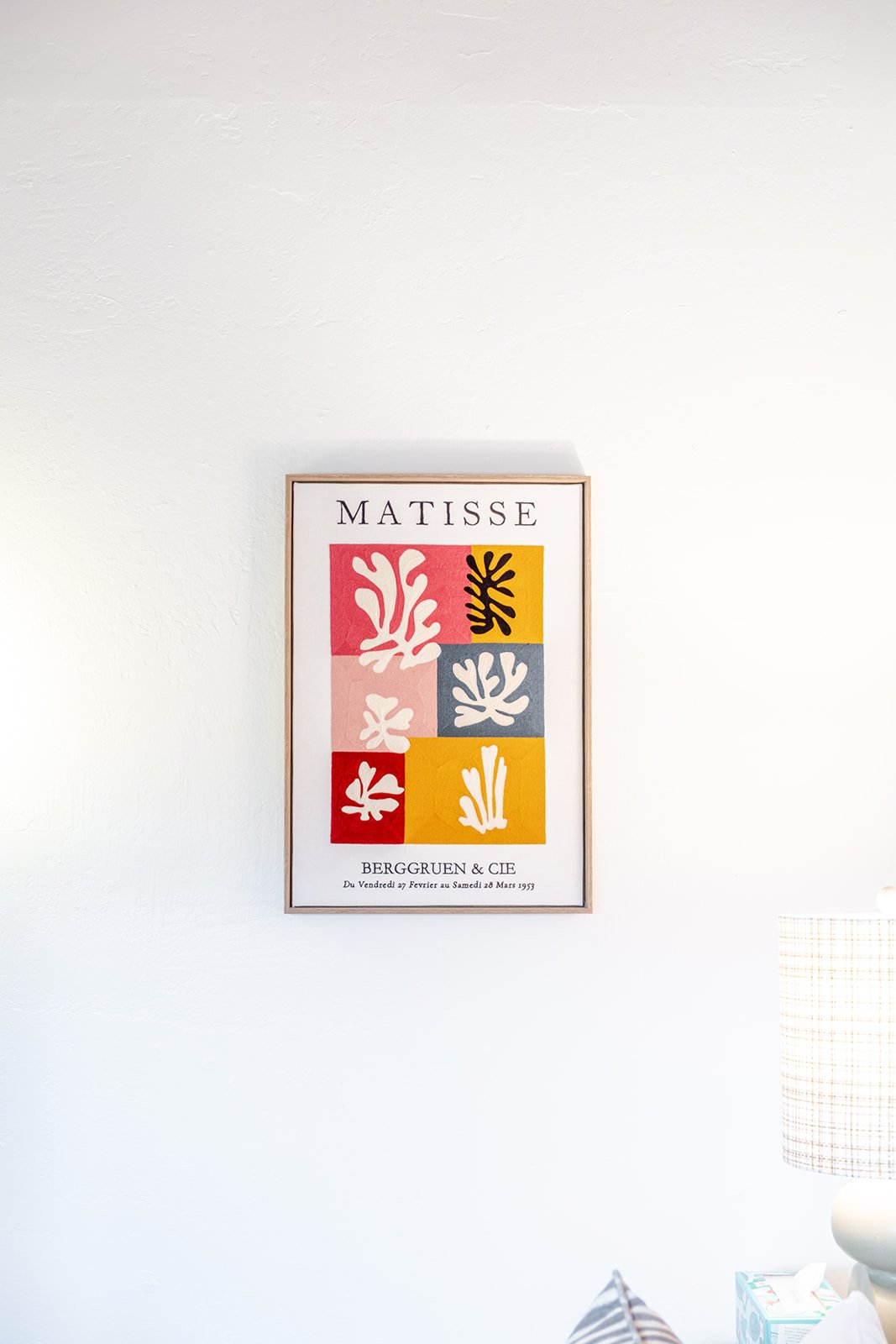 Framed art print on white wall featuring colorful abstract botanical shapes and the word 'Matisse' at the top, with text below referencing Berggren & Cie and a date range.