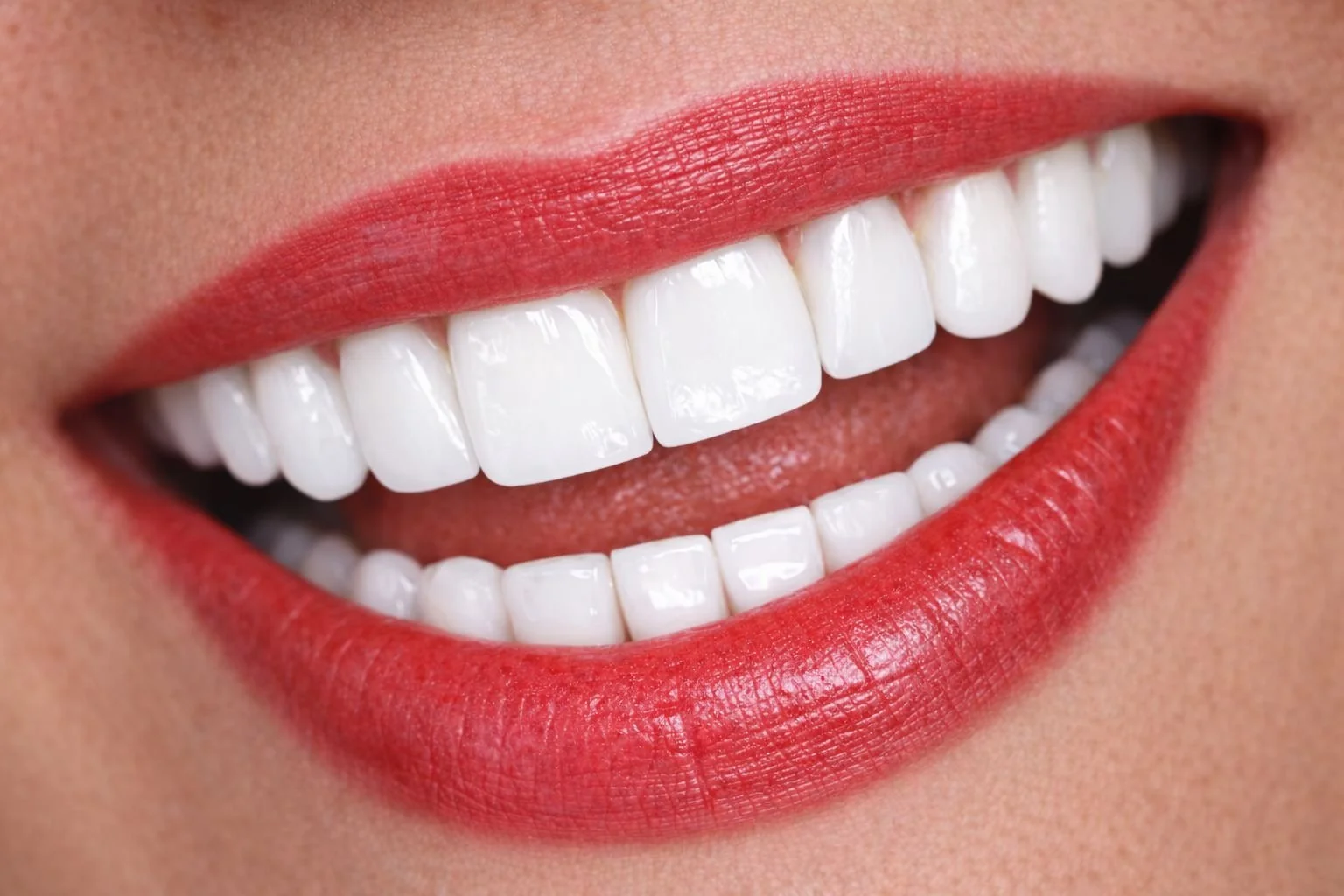 Sonrisa con dientes blancos y labios pintados de rojo.