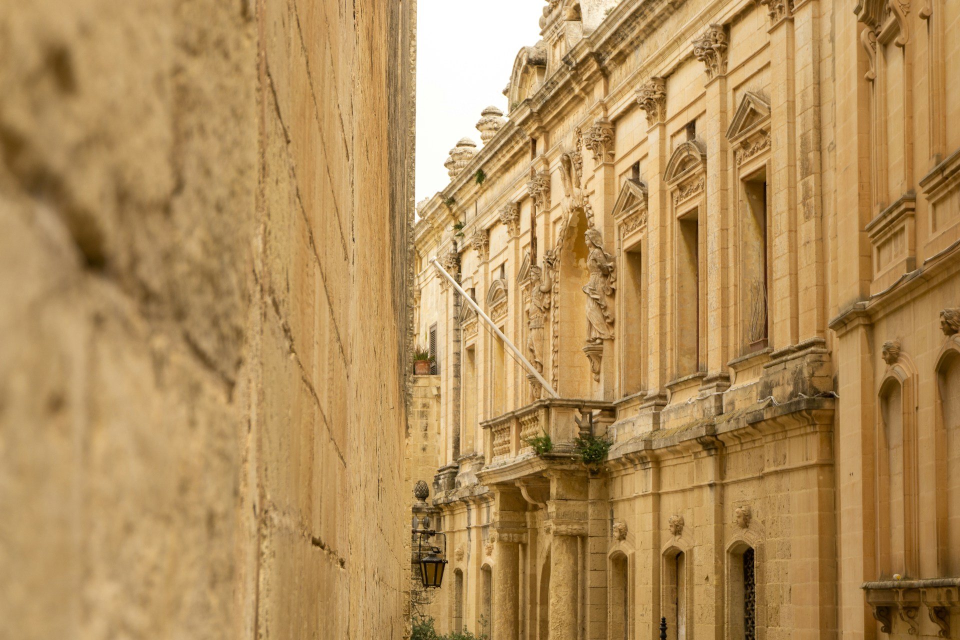 Limestone church facade in Malta within a narrow street, representing architectural permanence and the spatial framework of the urban environment
