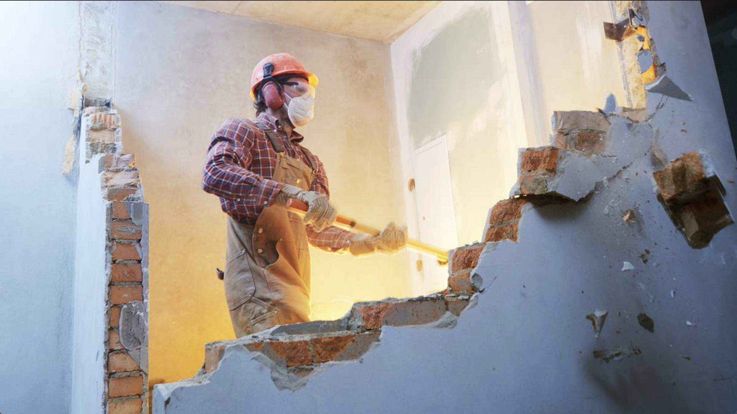 brick wall demolition with sledge hammer