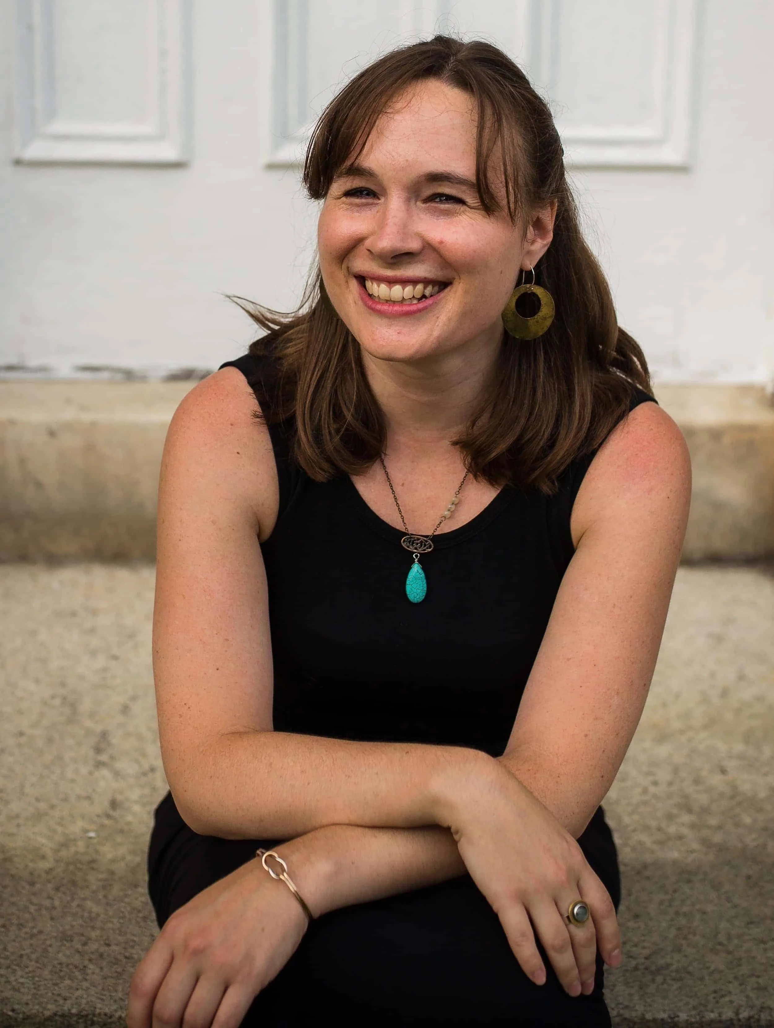 Alison Dagger- Somatic music therapist in Vermont- smiling sitting on steps