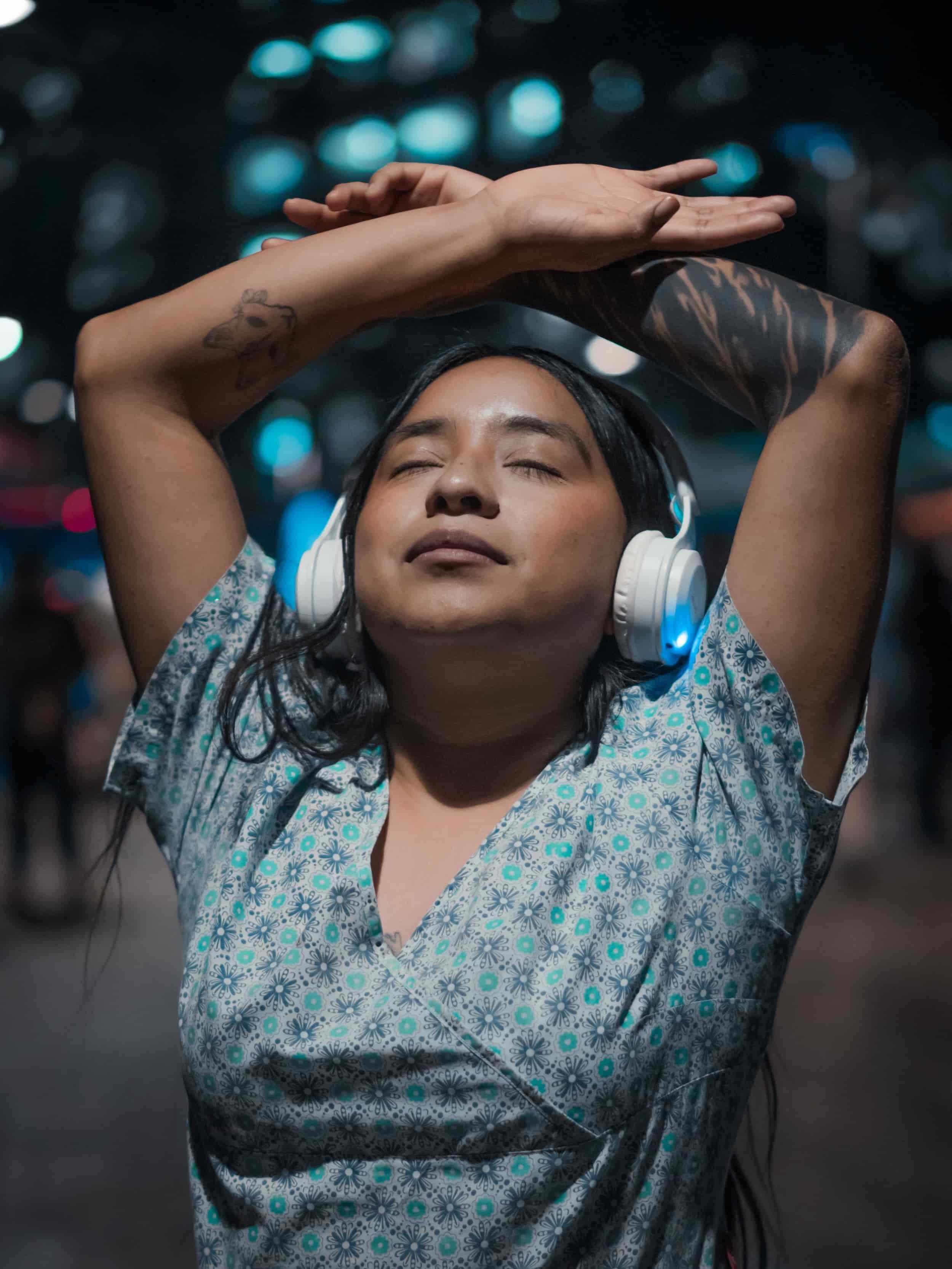 South Asian Woman in city listening to music with peaceful expression