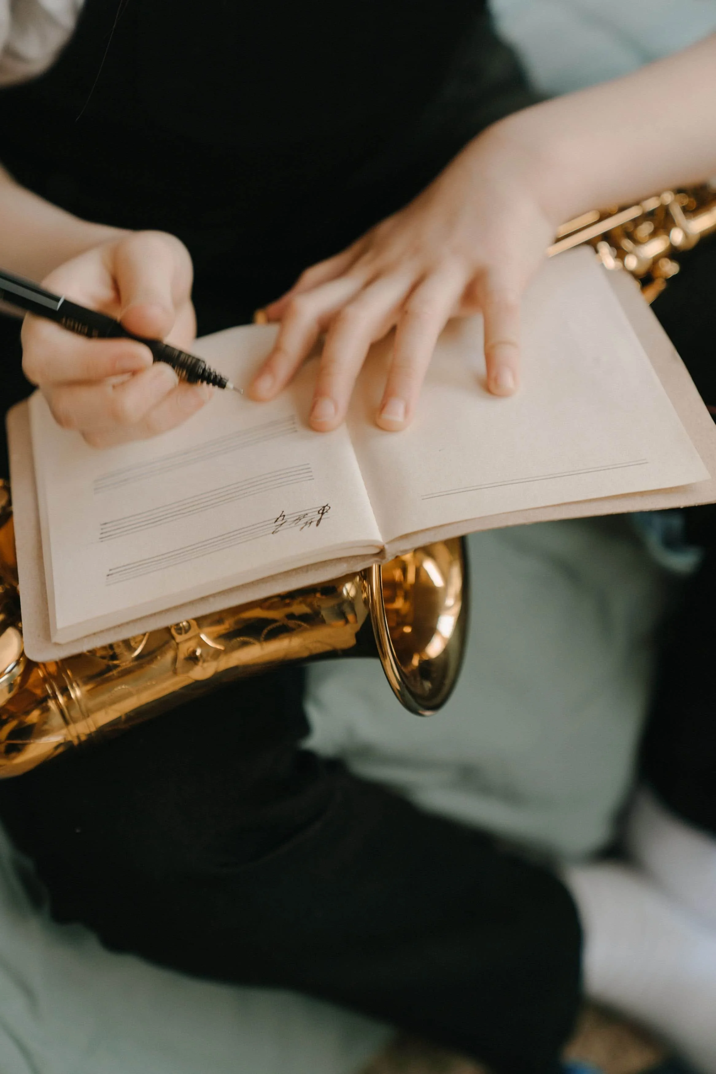 Person journaling holding a saxophone