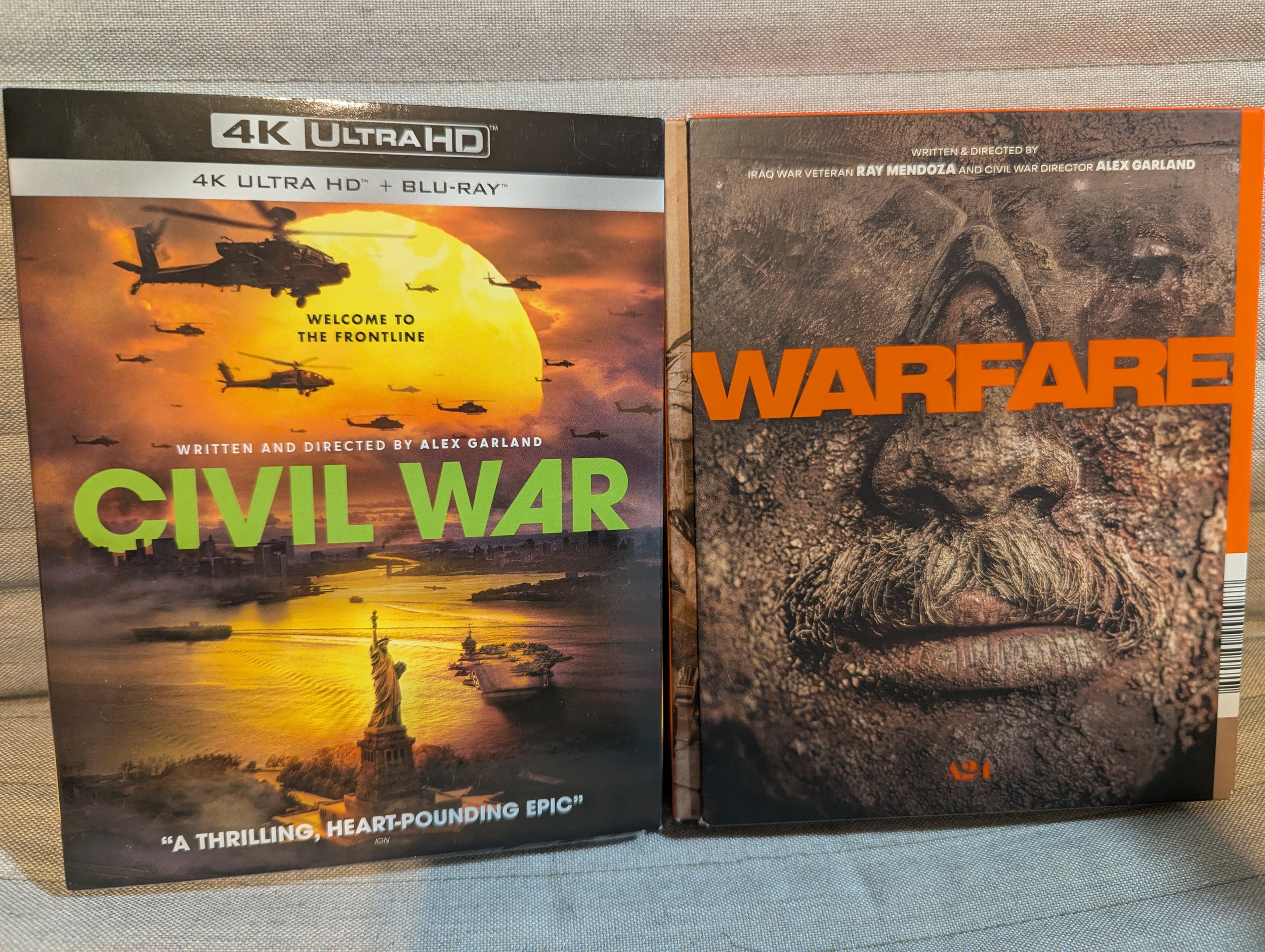 Two Blu-ray cases. Left is "Civil War," title centred. Military helicopters fly over the Statue of Liberty in front of huge sun. On right is "Warfare," title centred. Close-up of mans face covered with dirt and shrapnel, gray moustache, goggles.