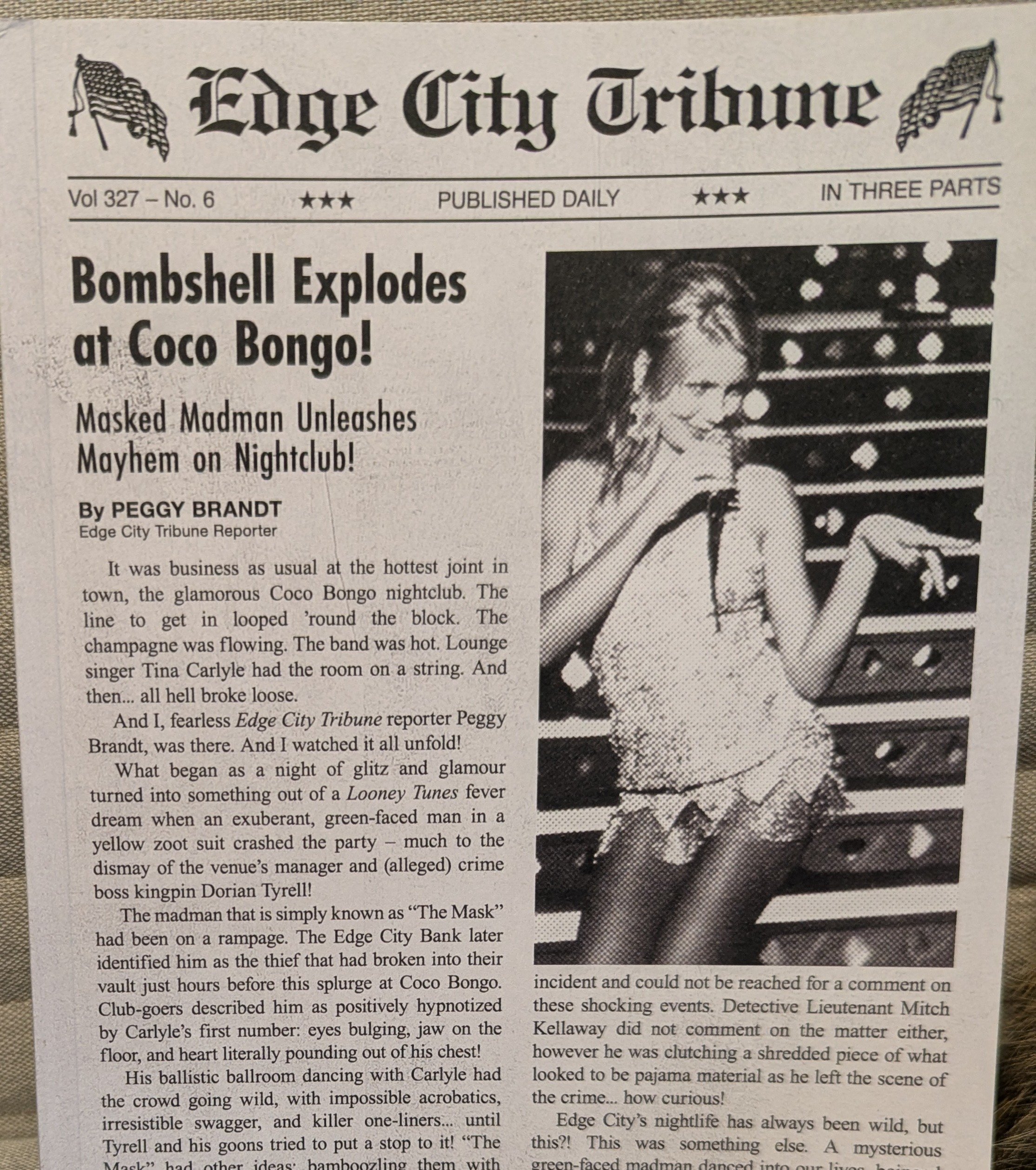 Close-up image of the cover, which replicates a printed newspaper with two columns and black and white photo of Cameron Diaz under newspaper title "Edit City Tribune" with U.S. flags beside title. Headline is "Bombshell Explodes at Coco Bongo!"