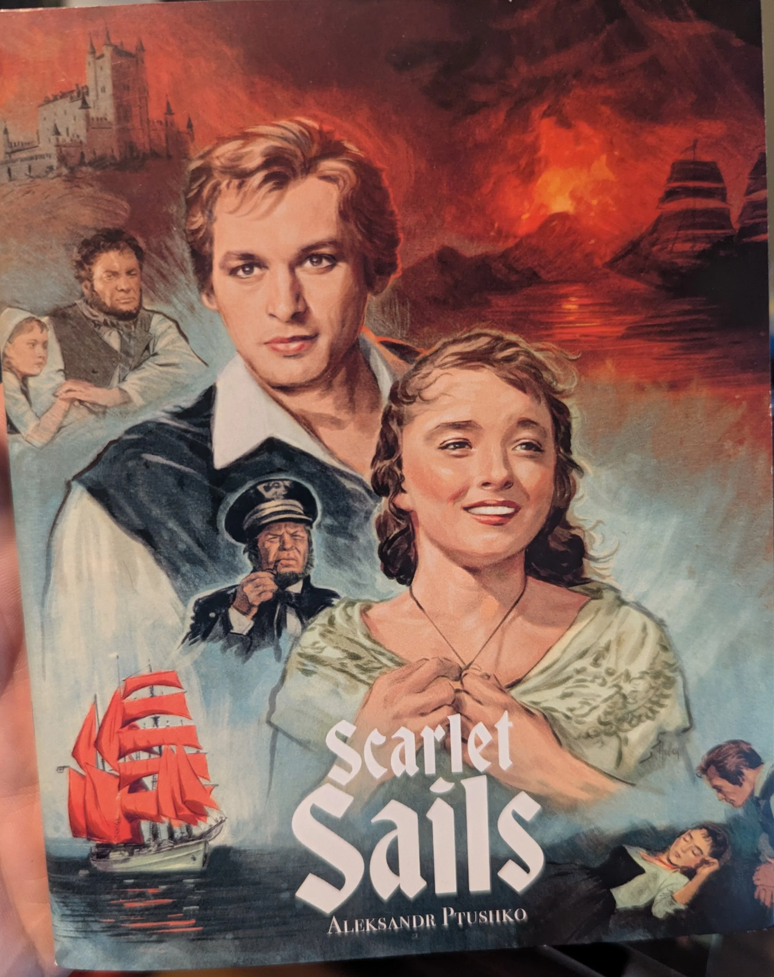 "Scarlet Sails" booklet cover. A painted montage of images and characters from the film, including an image of a white ship with scarlet sails, castles, and a sea captain.