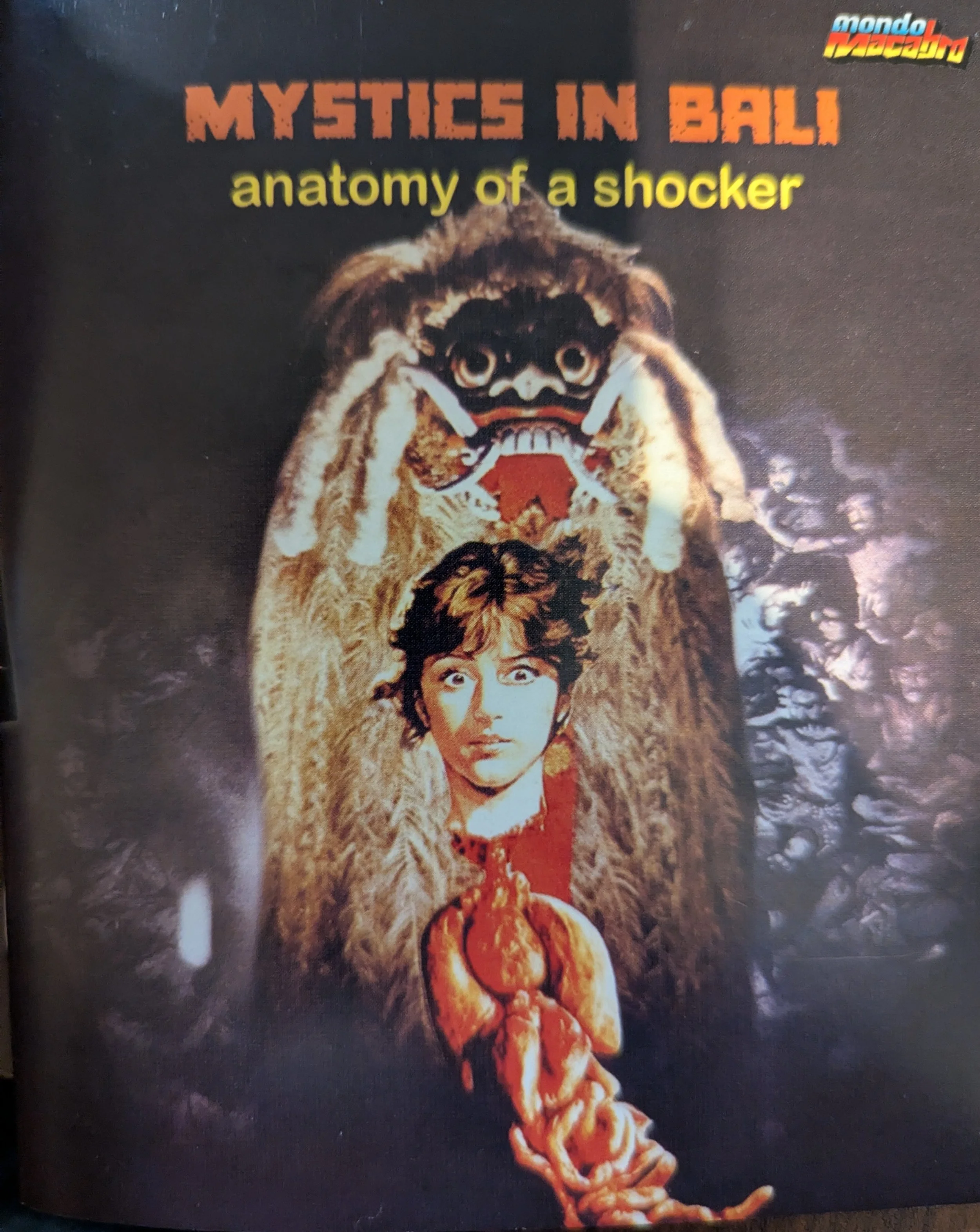 Mystics in Bali booklet cover has film title at top with subtitle "Anatomy of a shocker." Under that is a floating head of a woman with brown hair and white skin with entrails below it. Some sort of monster is behind her and demons in background.