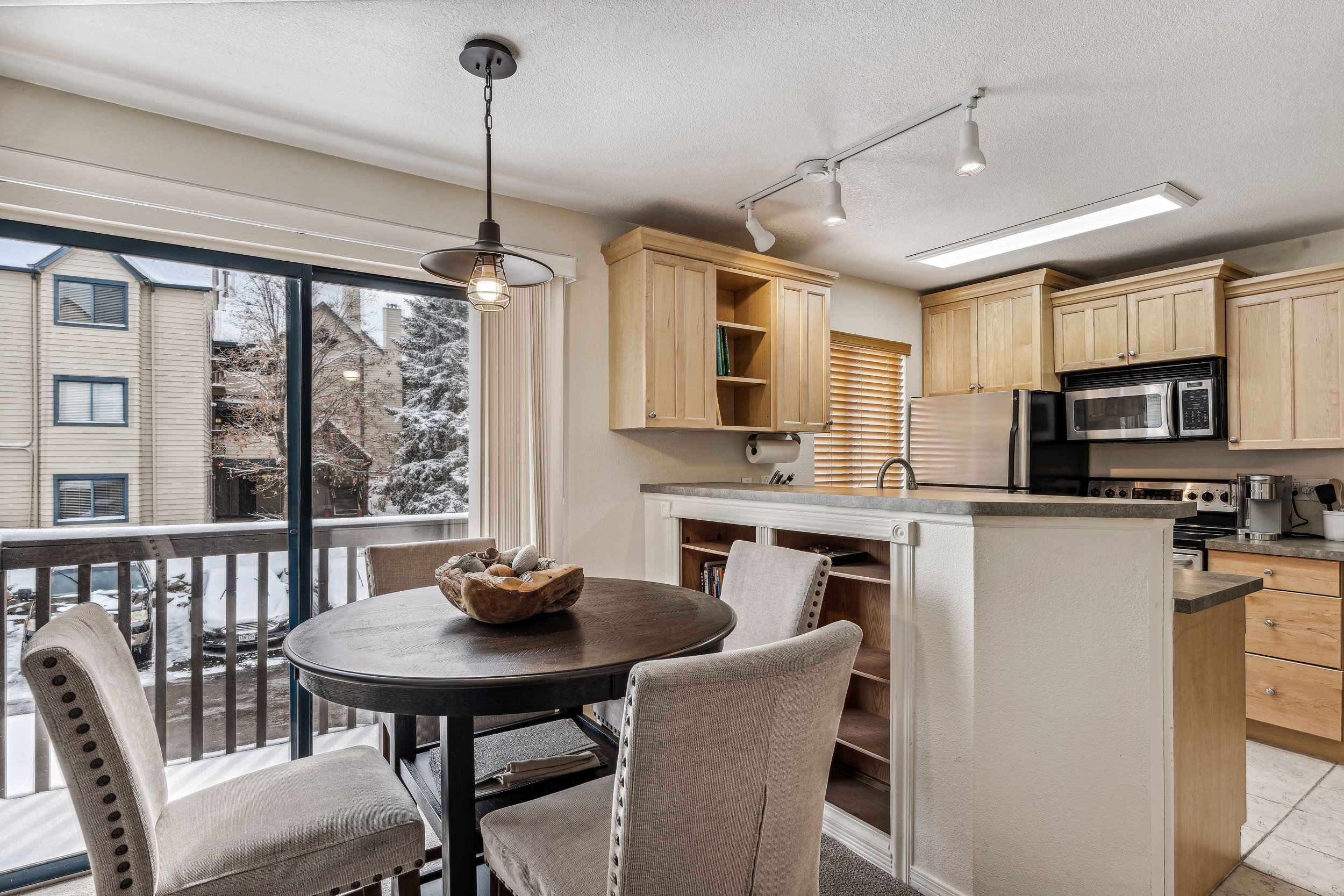 Unit 207 - A photograph of the dining area. Kitchen and patio featured. Angle 2.