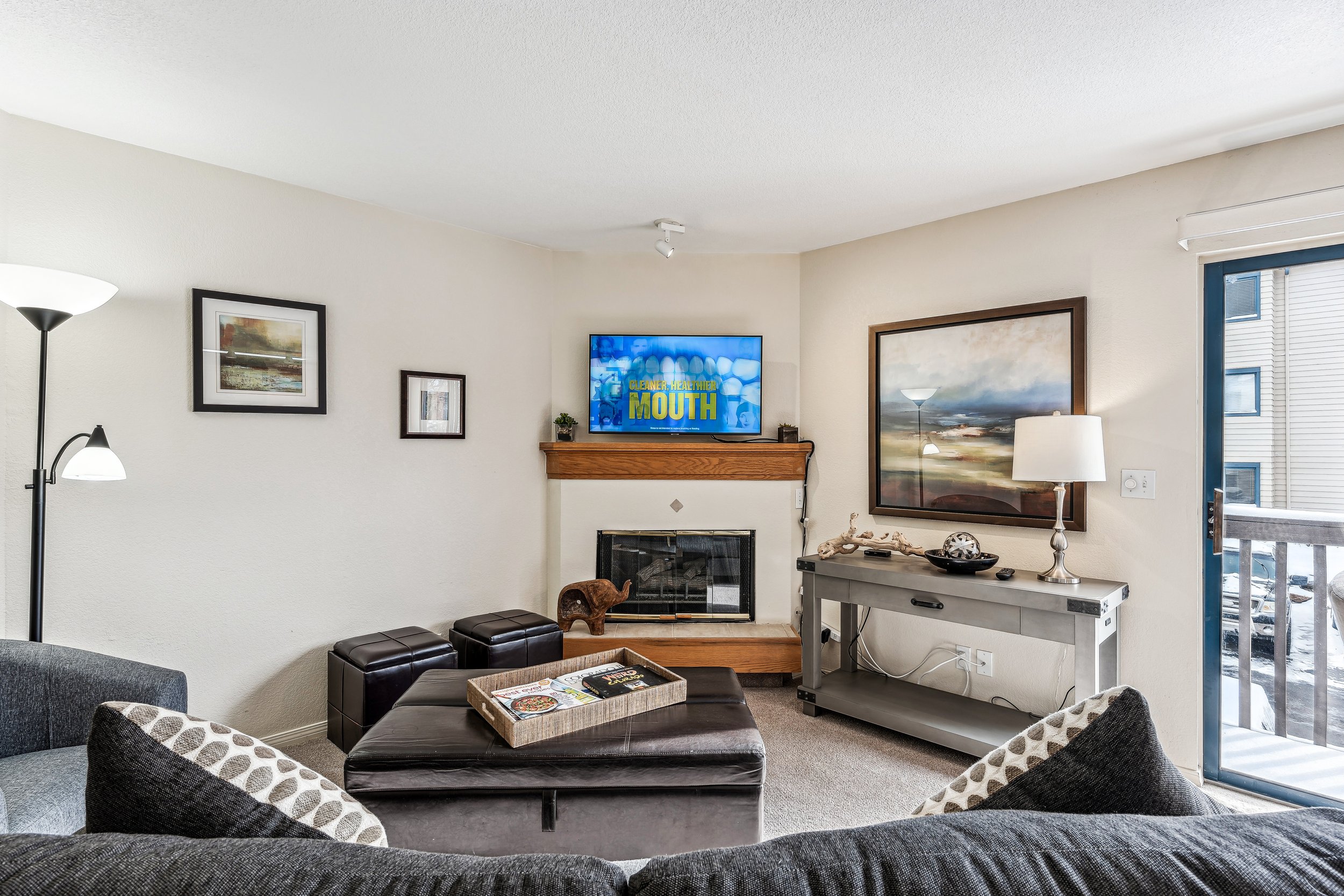 Unit 207 - A photograph of the living room. Flatscreen television and gas fireplace featured.