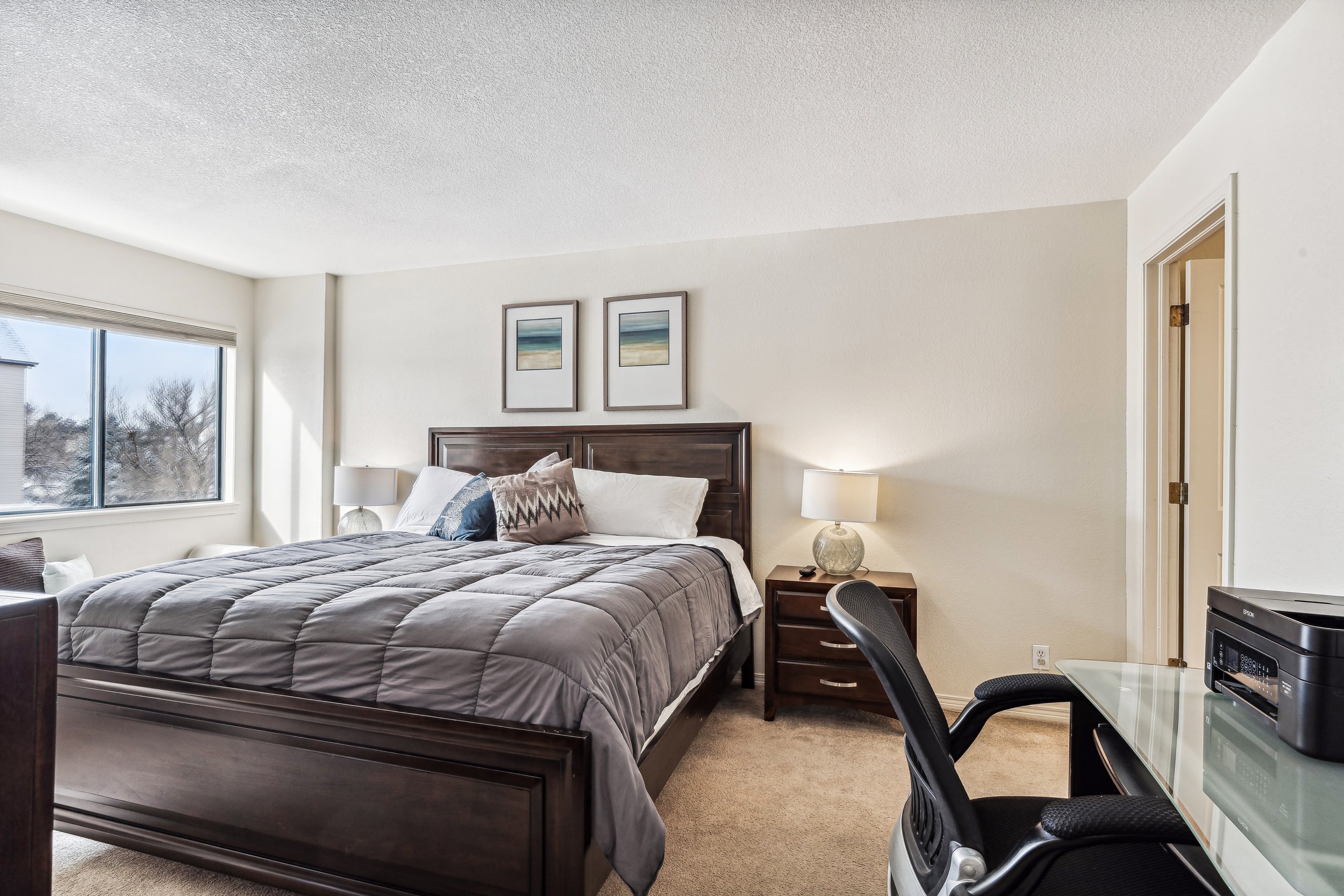 Unit 207 - A photograph of the large bedroom. Personal desk area featured.