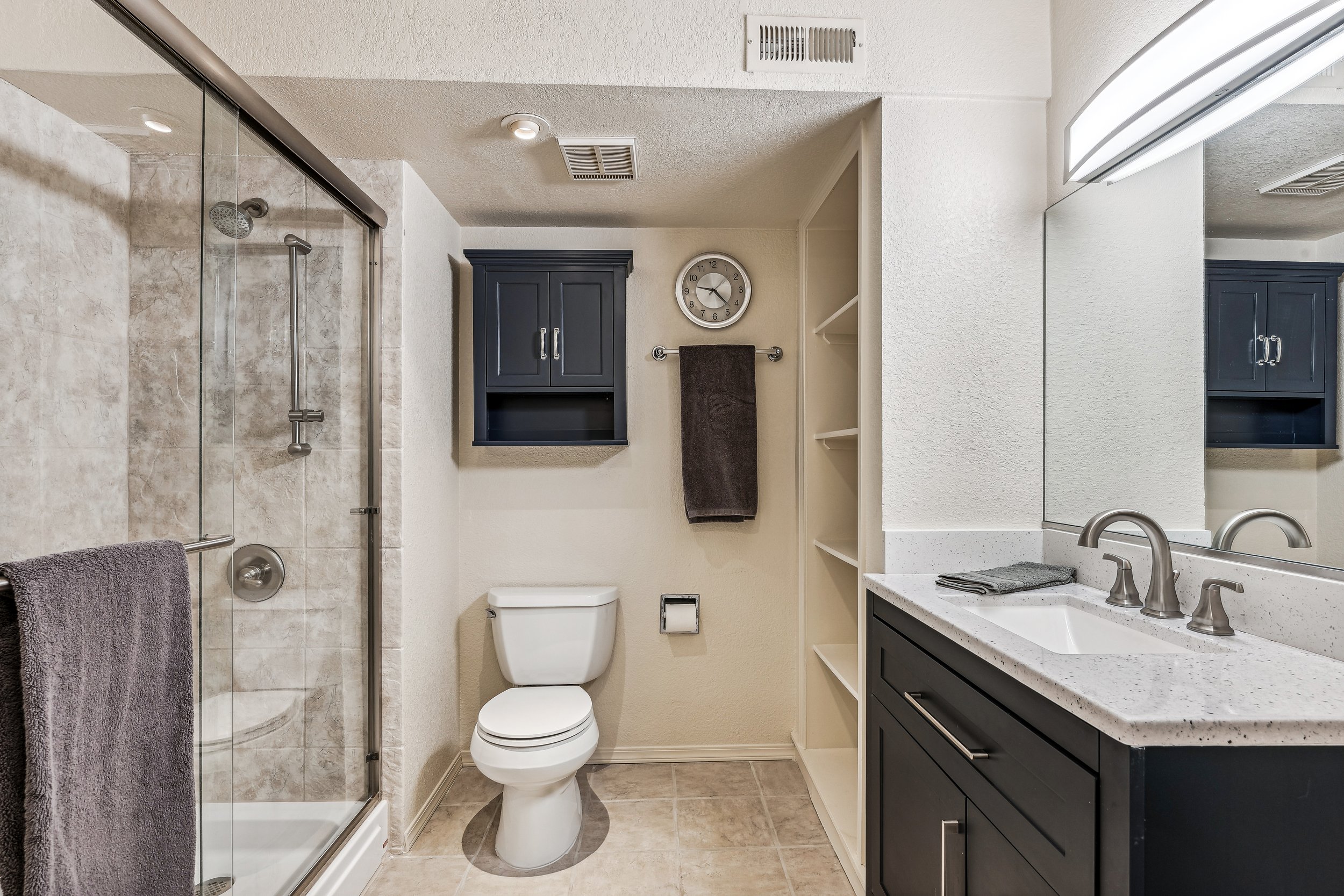 Unit 207 - A photograph of the large bathroom. Shower, toilet and sink featured.