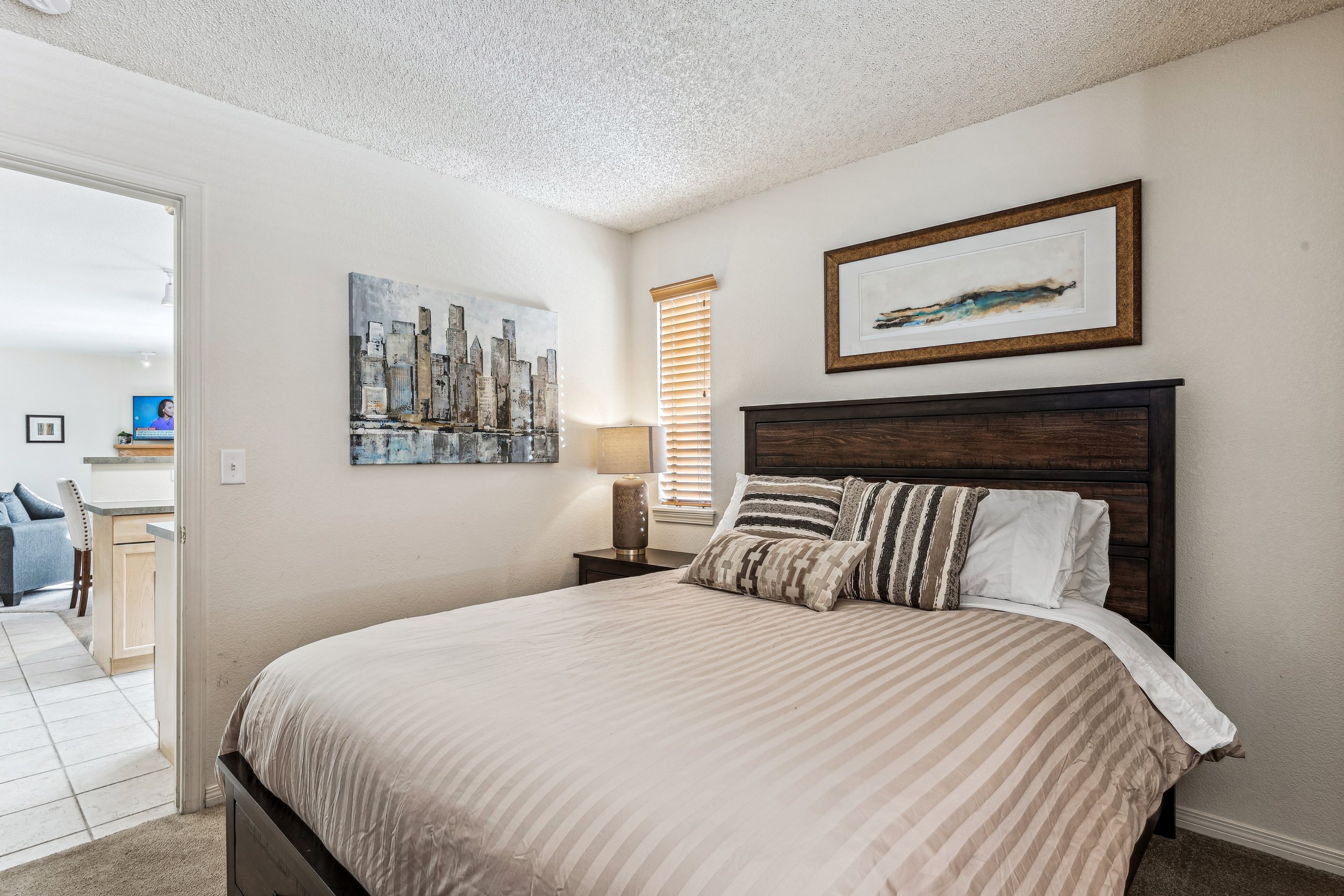 Unit 207 - A photograph of the smaller bedroom. Entry to kitchen featured.