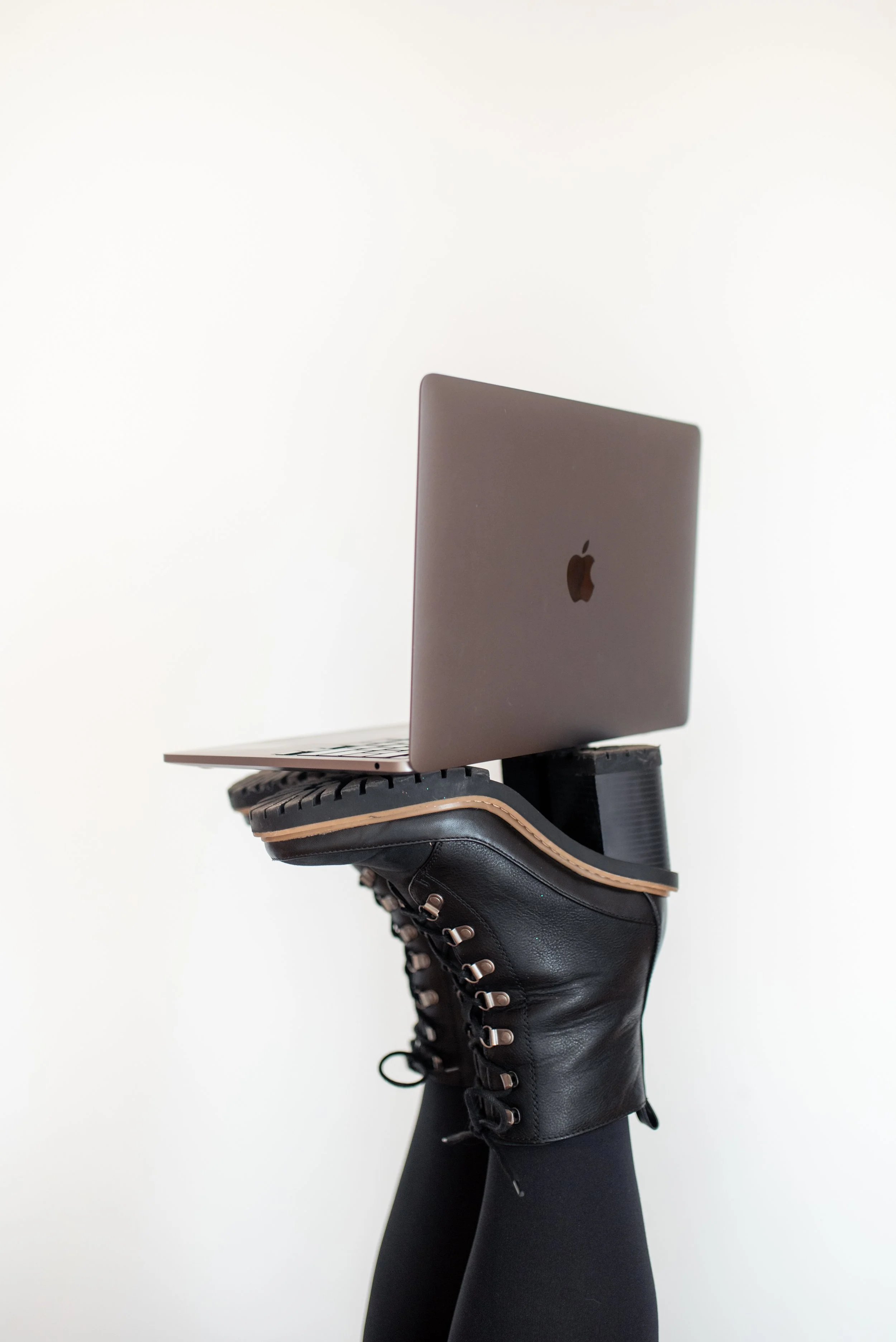 A fun studio shoot in Des Moines Iowa featuring laptop on boots captures by a brand photographer.