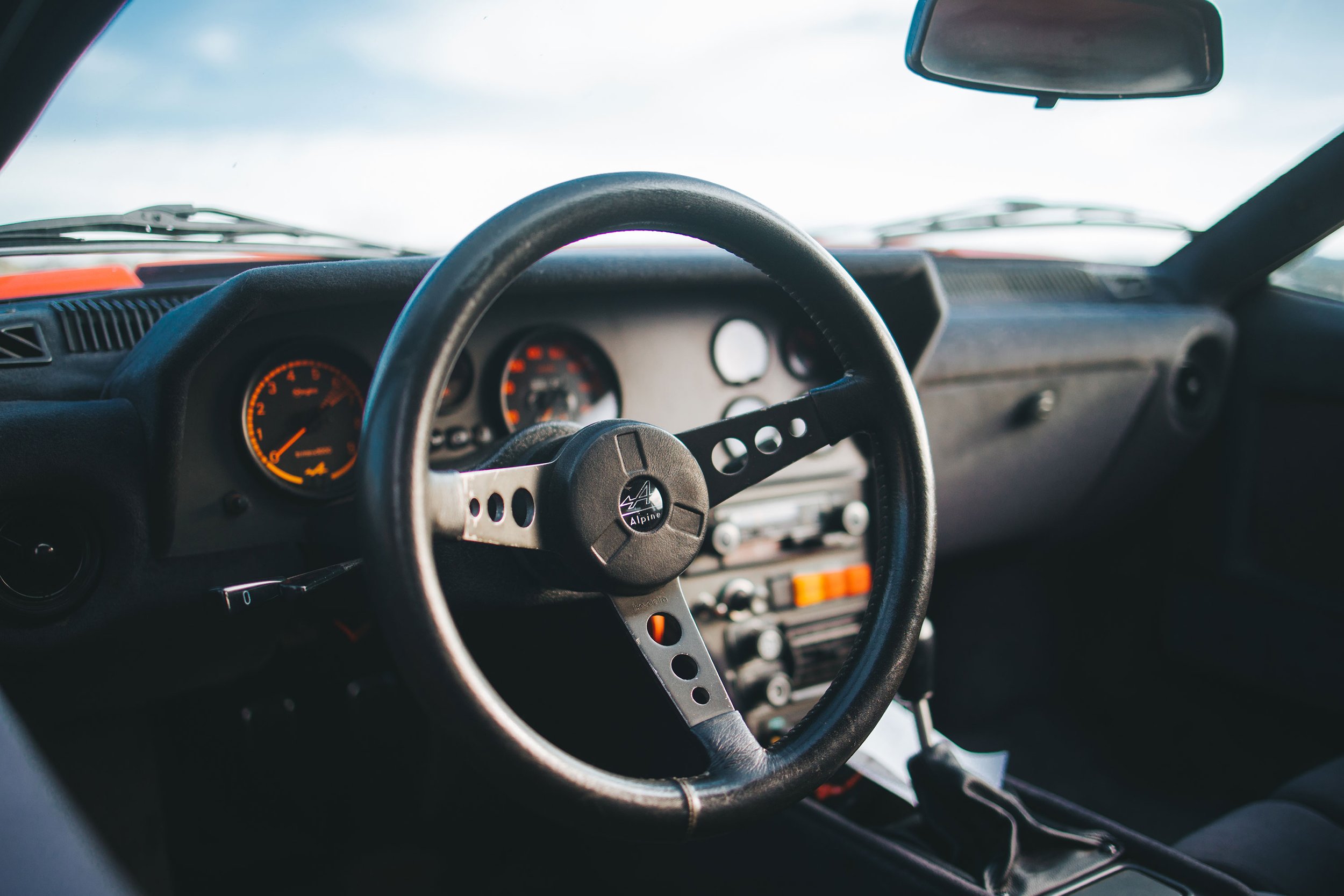 Interior cockpit view photo of a vintage 1980 red Alpine A310 car. Bespoke build by premium car restoration and modification workshop Retro Sporting in California.
