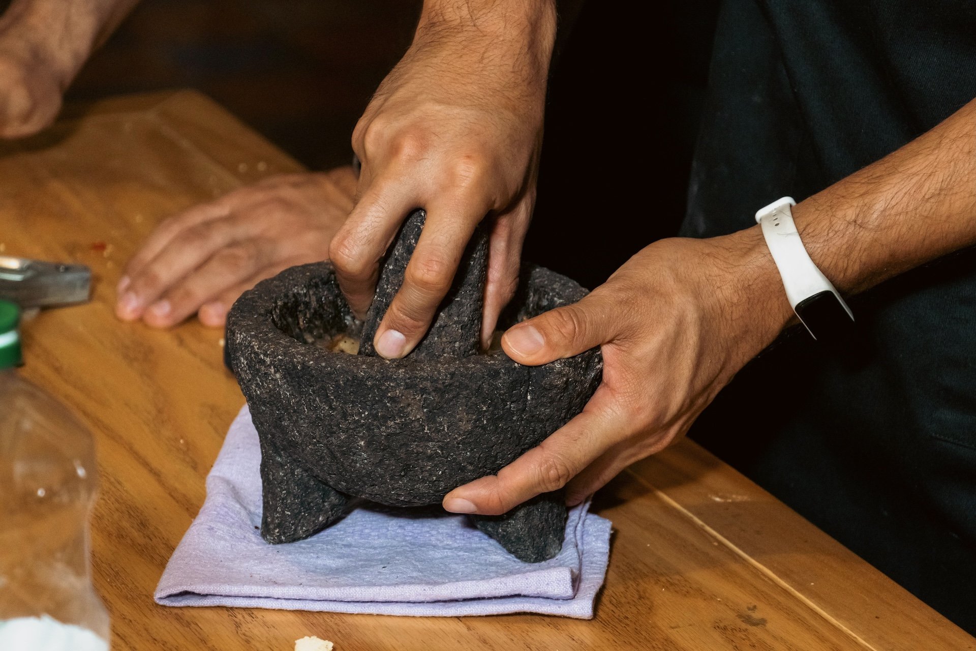 A Martaja guest makes a smoky red chipotle salsa in a traditional molcajete made from volcanic stone in a cooking class in Condesa, Mexico City.