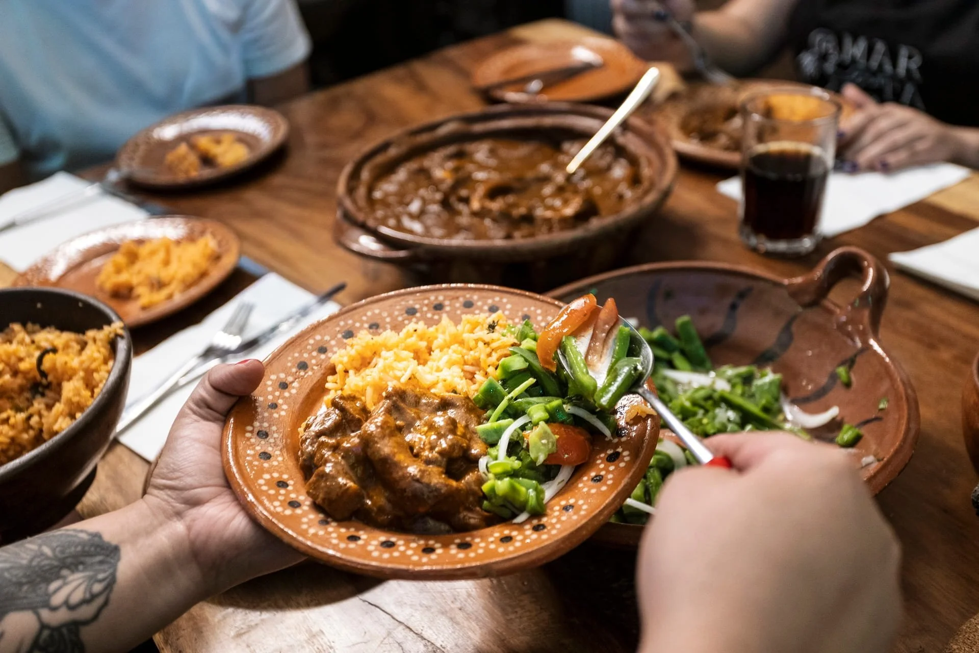 Guests serve themselves red mole, green mole, salads and more at the end of a cooking class in Mexico City.
