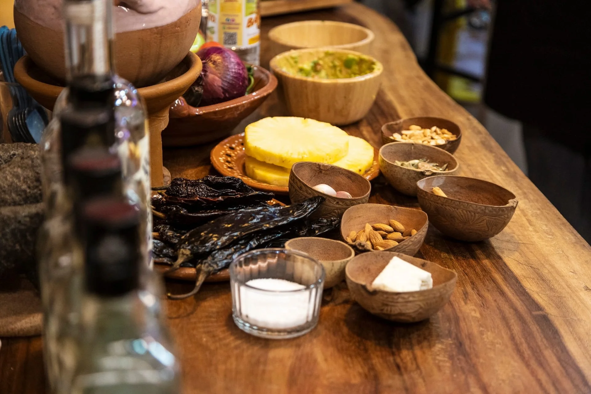 Ingredients for a mole making class in Mexico City, including fruit and seeds, all displayed in beautiful handmade bowls.